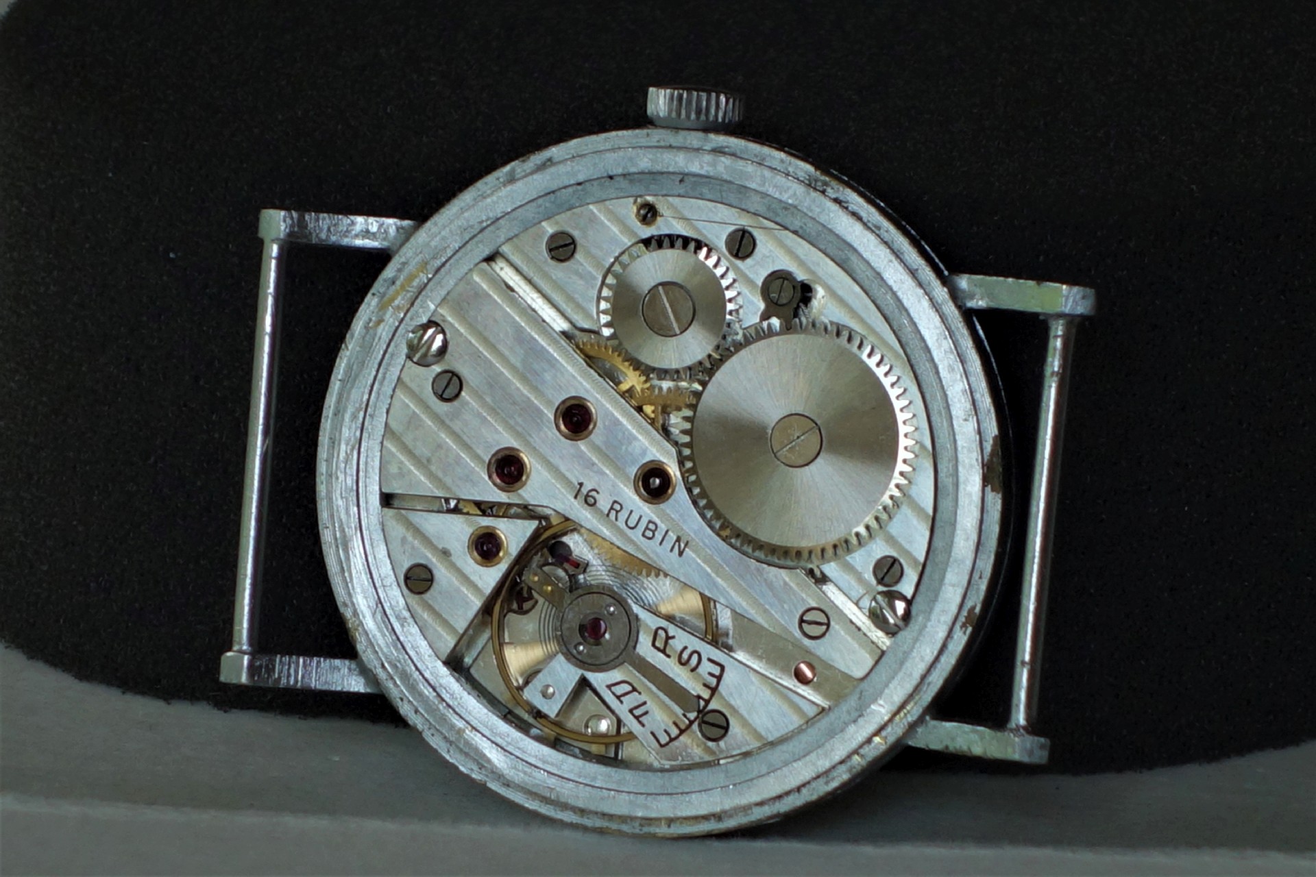 Silberfarbenes mechanisches Uhrwerk mit sichtbaren Zahnrädern und der Gravur "16 Rubin".