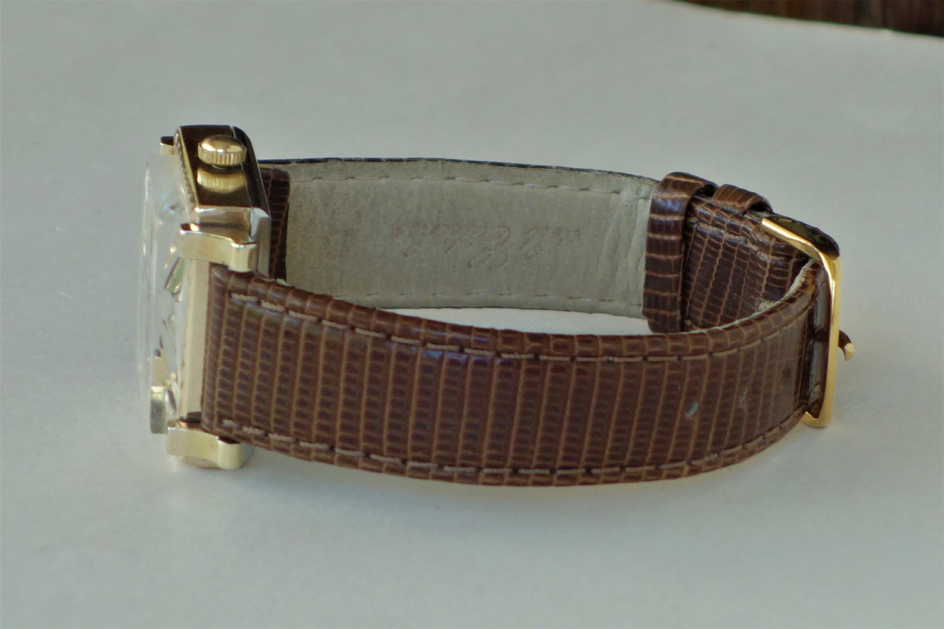 Armbanduhr mit braunem Lederarmband und goldfarbenem Gehäuse.