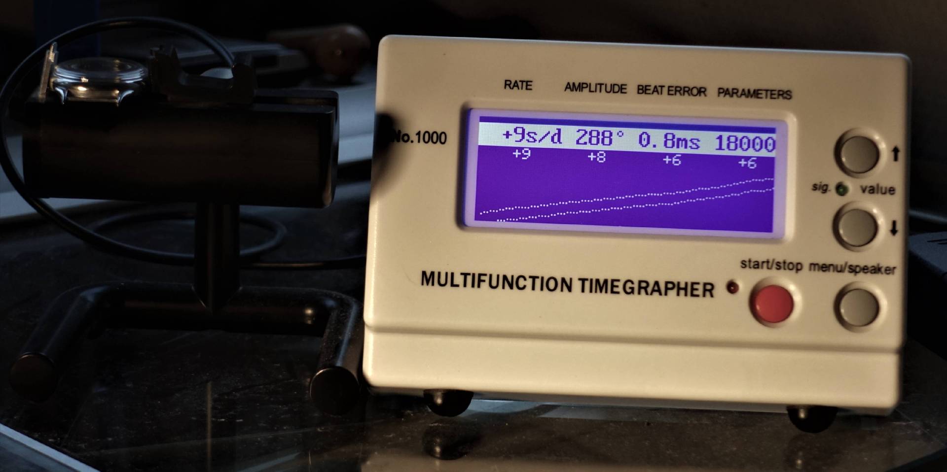 Elektronisches Messgerät zur Analyse von mechanischen Uhren mit digitalem Display und Bedientasten.
