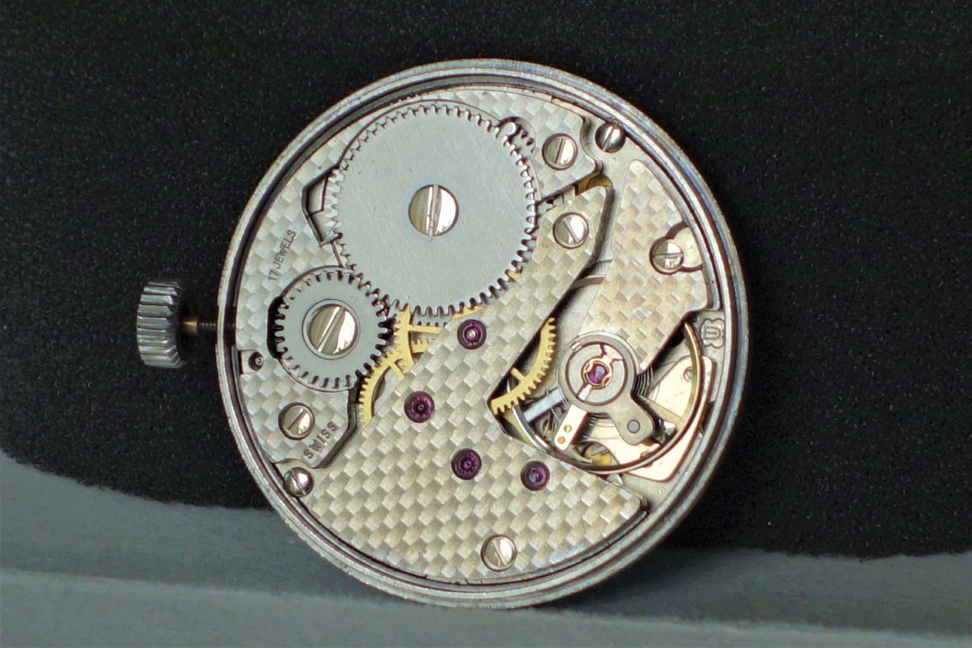 Mechanisches silberfarbenes Uhrwerk mit sichtbaren Zahnrädern und Aufzugskrone.