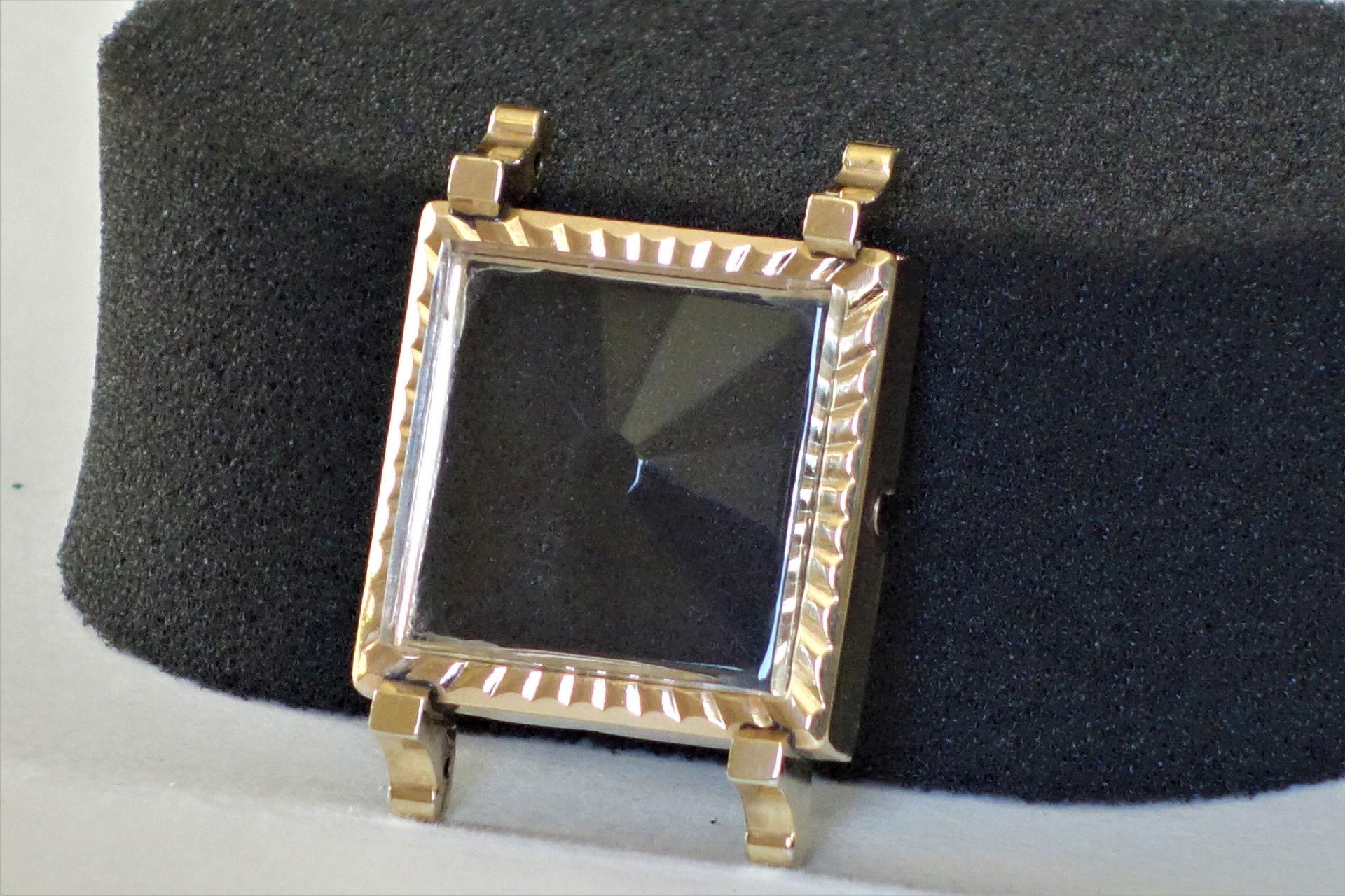 Rechteckiges Metallgehäuse für Armbanduhren mit Glasabdeckung.