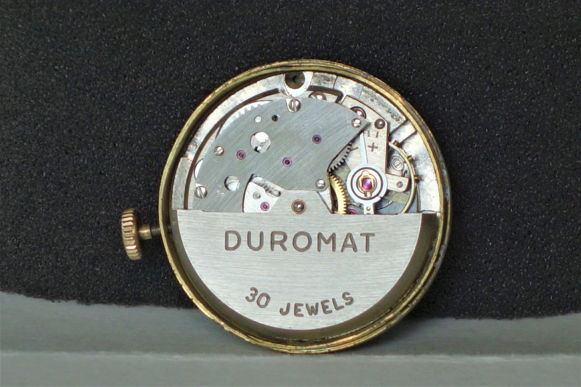 Mechanisches Uhrwerk mit silberfarbenen Bauteilen und der Aufschrift "DUROMAT 30 JEWELS".