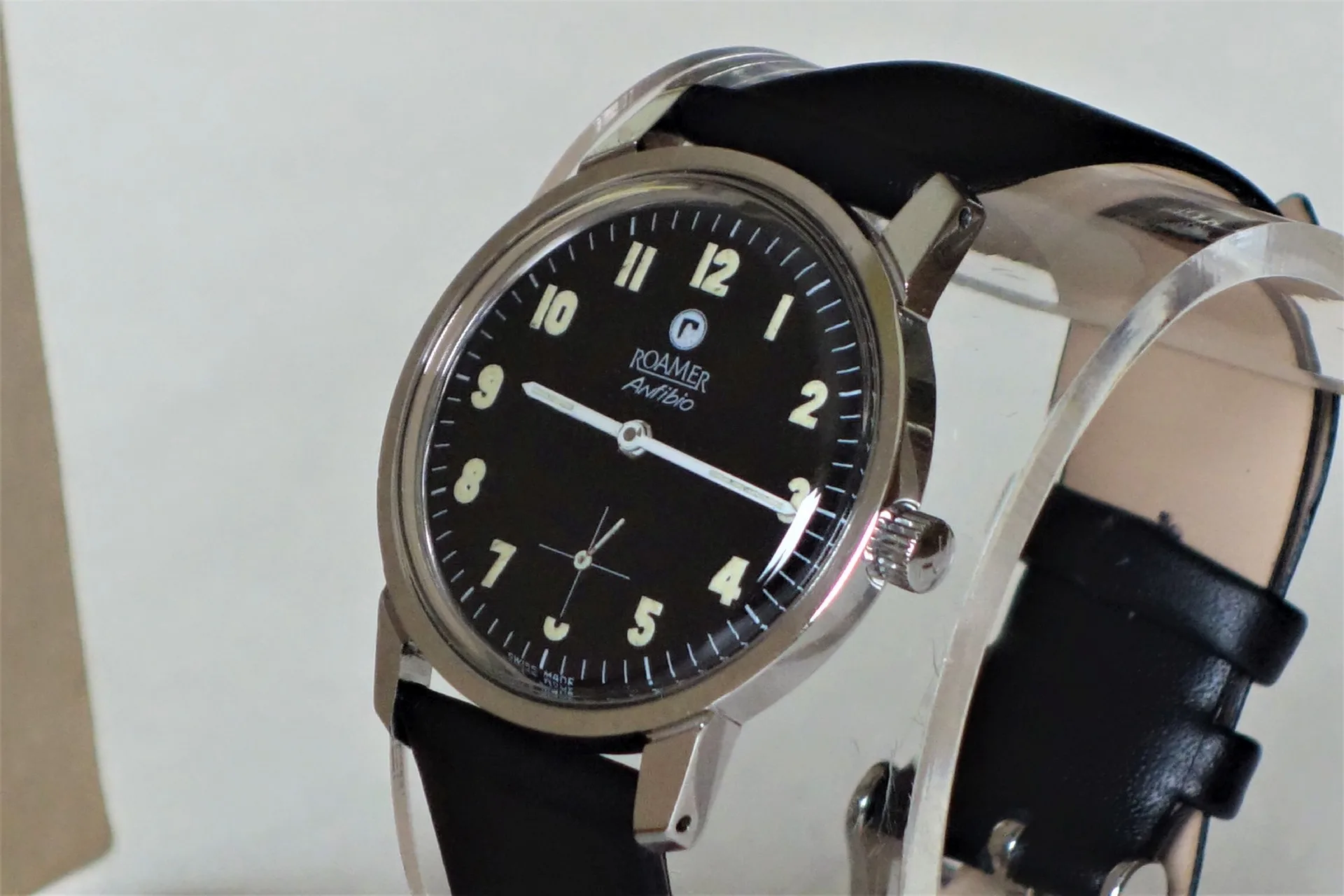 Schwarze Armbanduhr mit hellem Zifferblatt und schwarzem Armband.