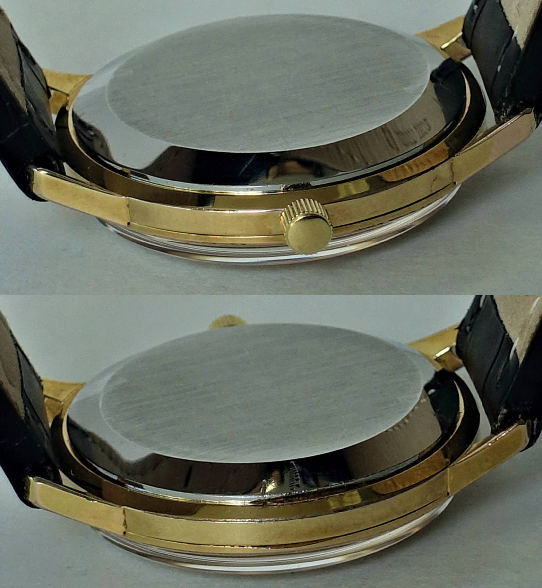 Rundes Uhrengehäuse mit goldfarbener Lünette, silberfarbener Rückseite und seitlicher Krone, an schwarzem Armband.