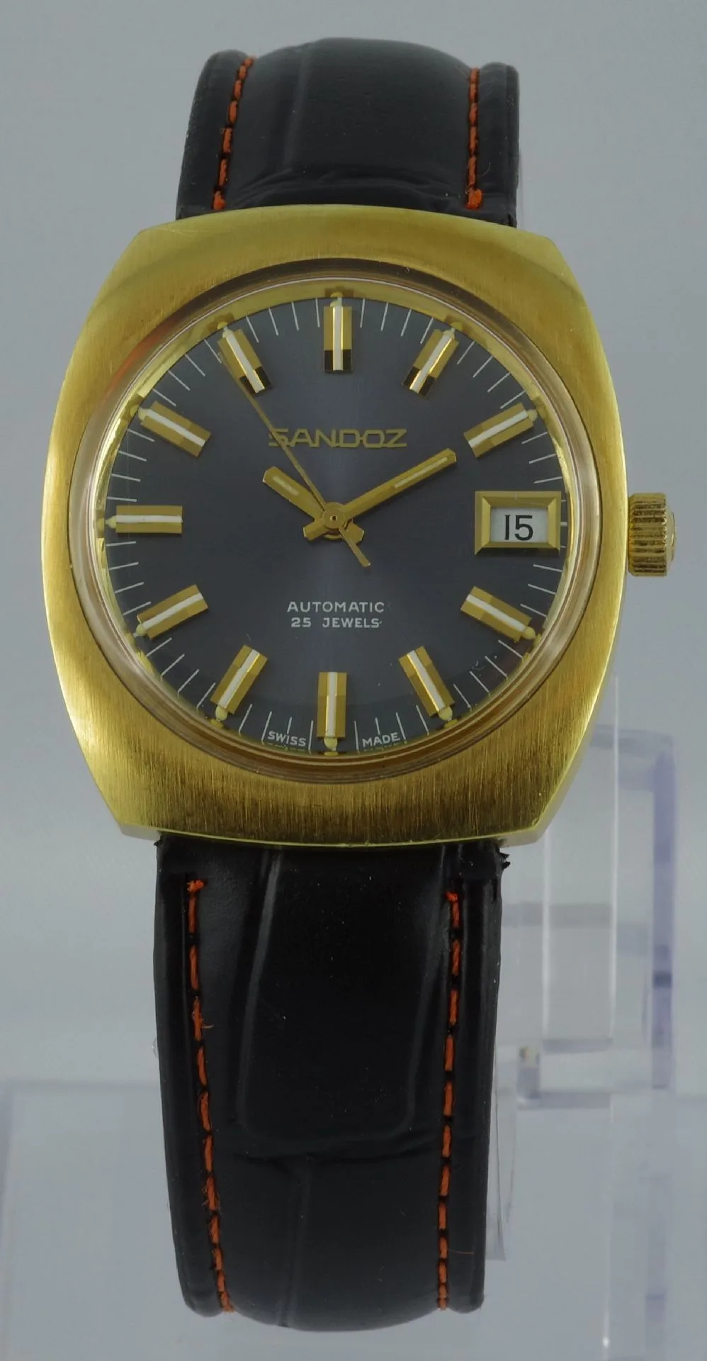 Automatik Armbanduhr goldfarben Goldfarbene automatische Armbanduhr mit schwarzem Zifferblatt und schwarzem Lederarmband mit orangefarbener Naht.