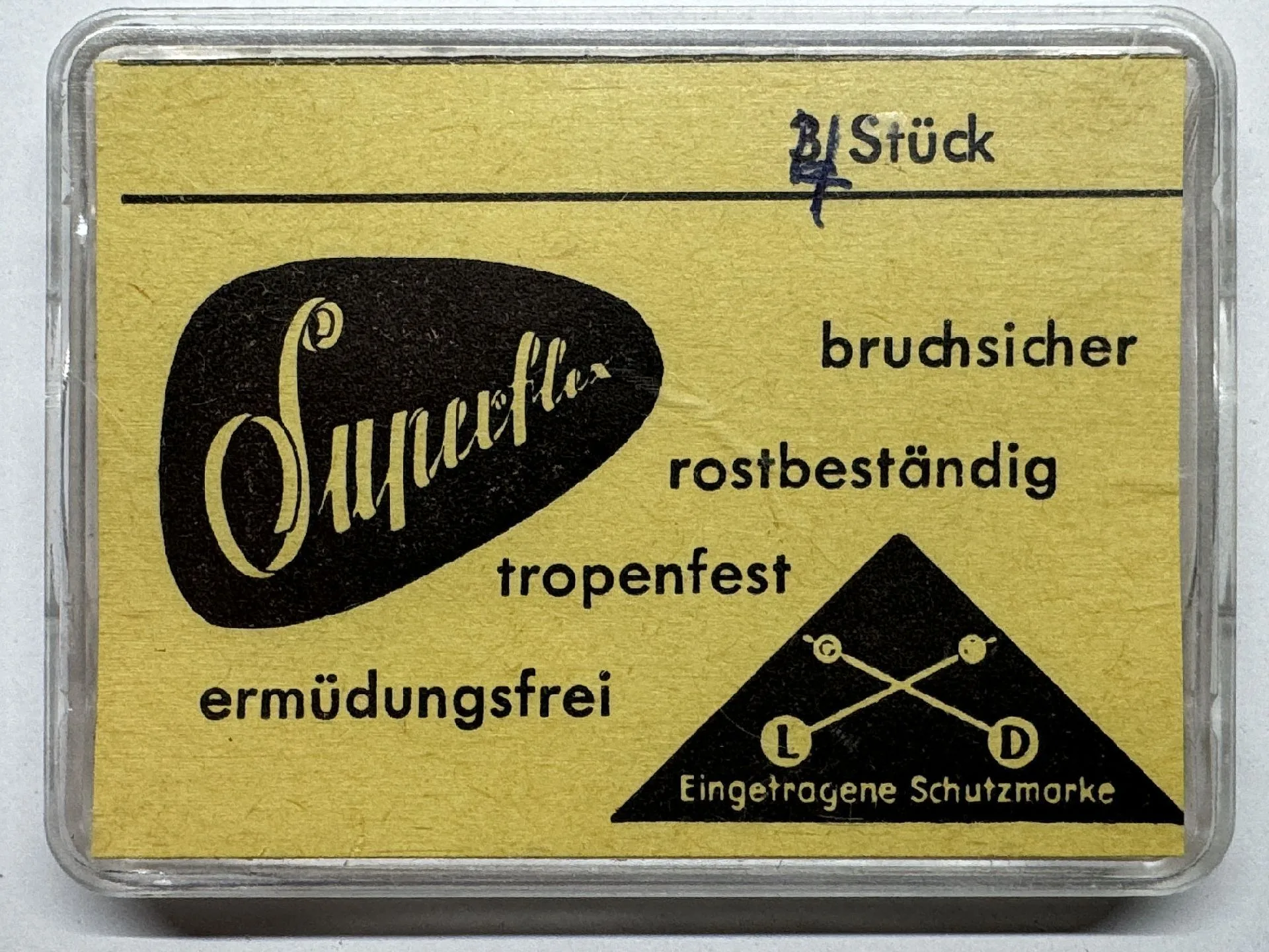 Superflex Uhrmacherfeder Gelbe Verpackung mit der Aufschrift "Superflex" für eine bruchsichere und rostbeständige Uhrmacherfeder.