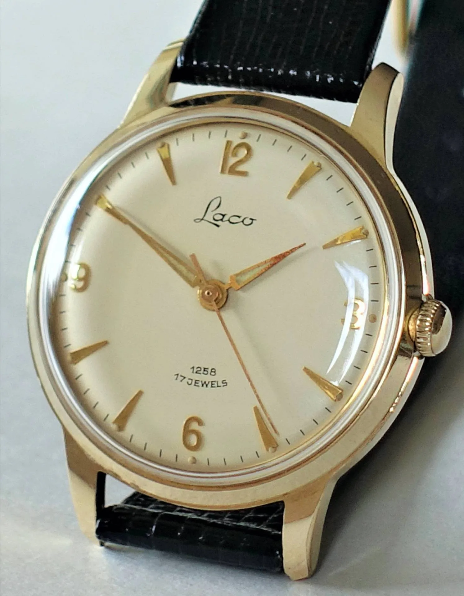 Laco Armbanduhr goldfarben Goldfarbene Armbanduhr mit hellem Zifferblatt und schwarzem Armband.