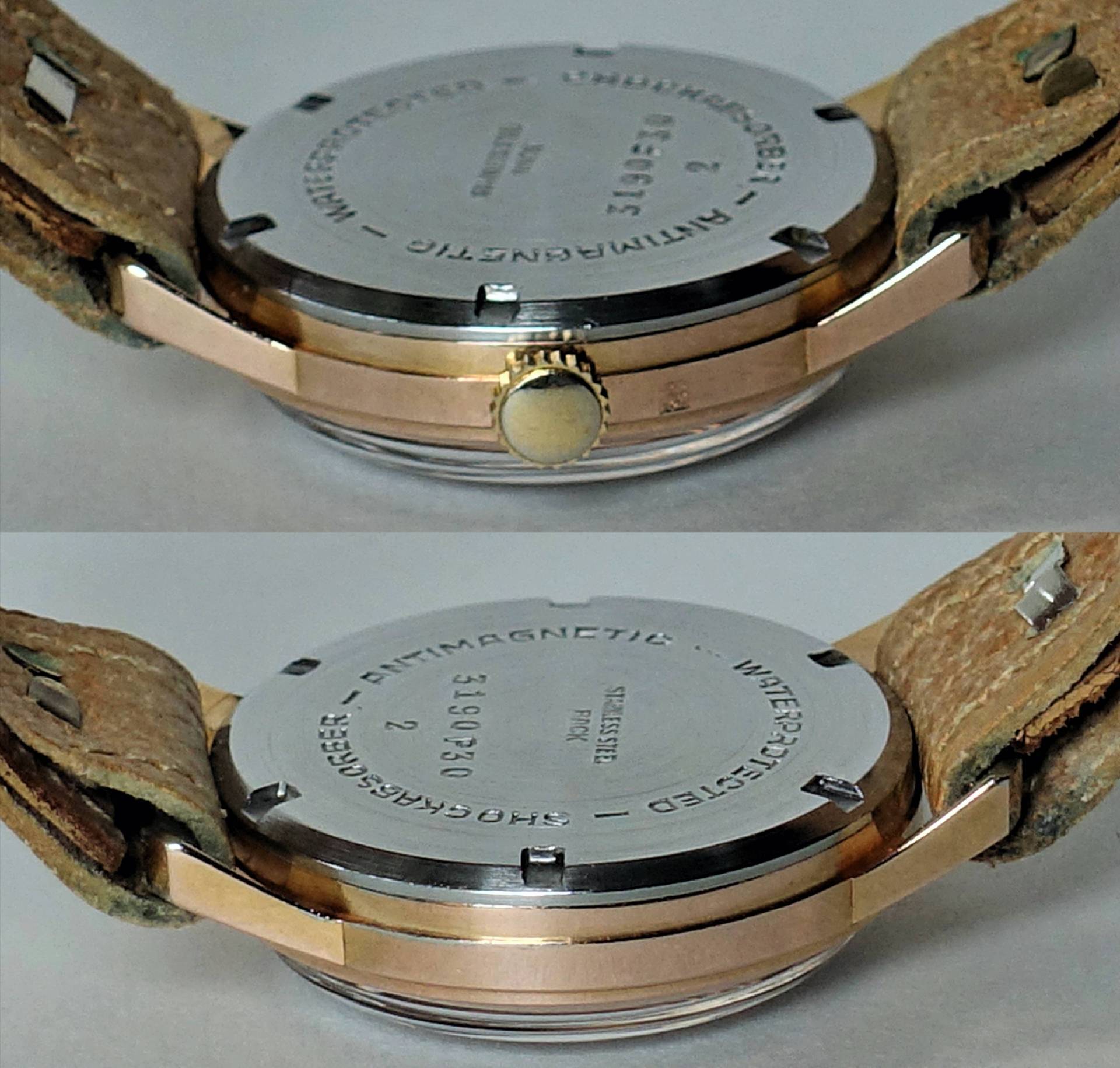 Silberfarbener runder Uhrenboden mit Gravur und braunem Lederarmband.