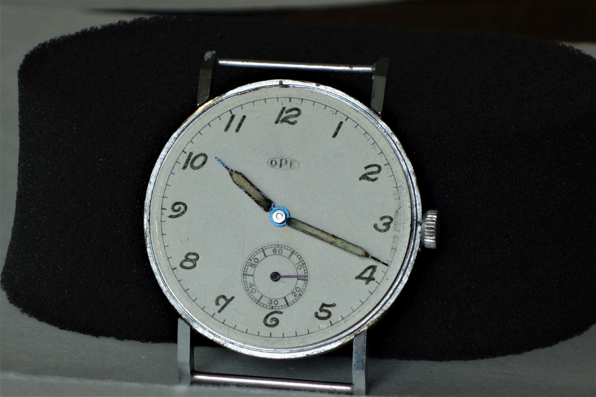 Runde mechanische Armbanduhr mit silberfarbenem Gehäuse und weißem Zifferblatt.