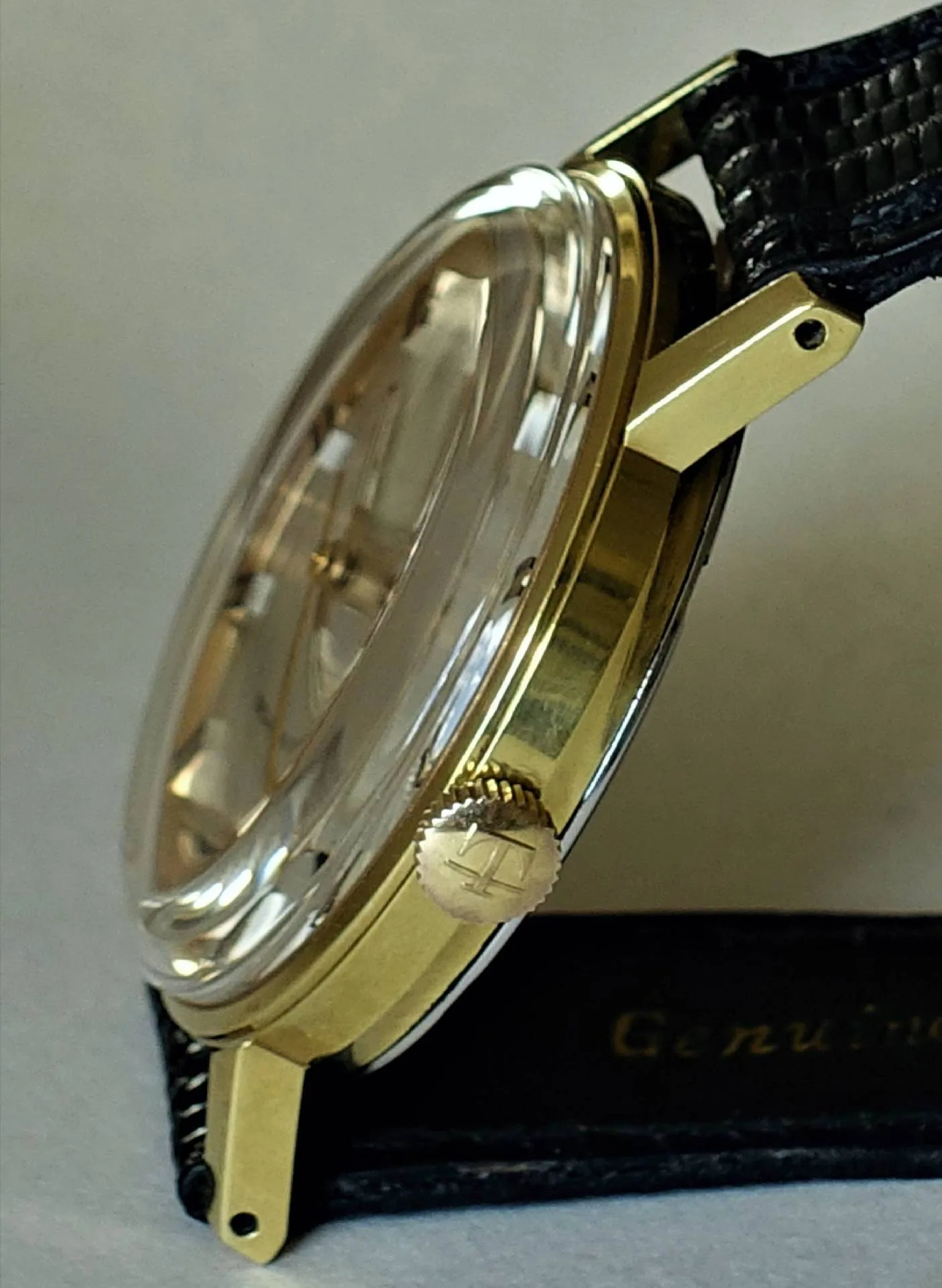 Armbanduhr goldfarben Goldfarbene Armbanduhr mit schwarzem Armband und transparenter Abdeckung.