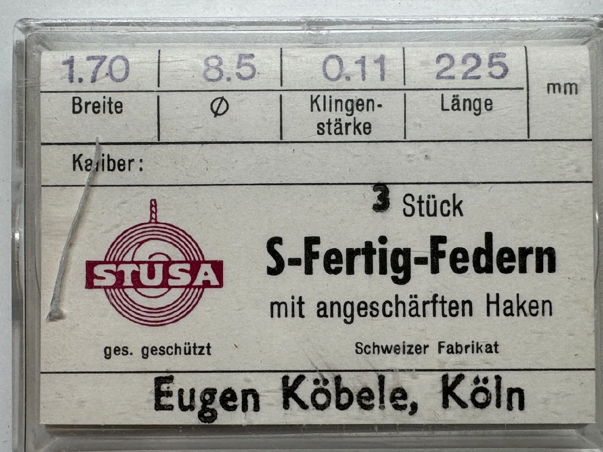 Drei silberfarbene Fertigfedern mit angeschärften Haken für Uhren in transparenter Verpackung.