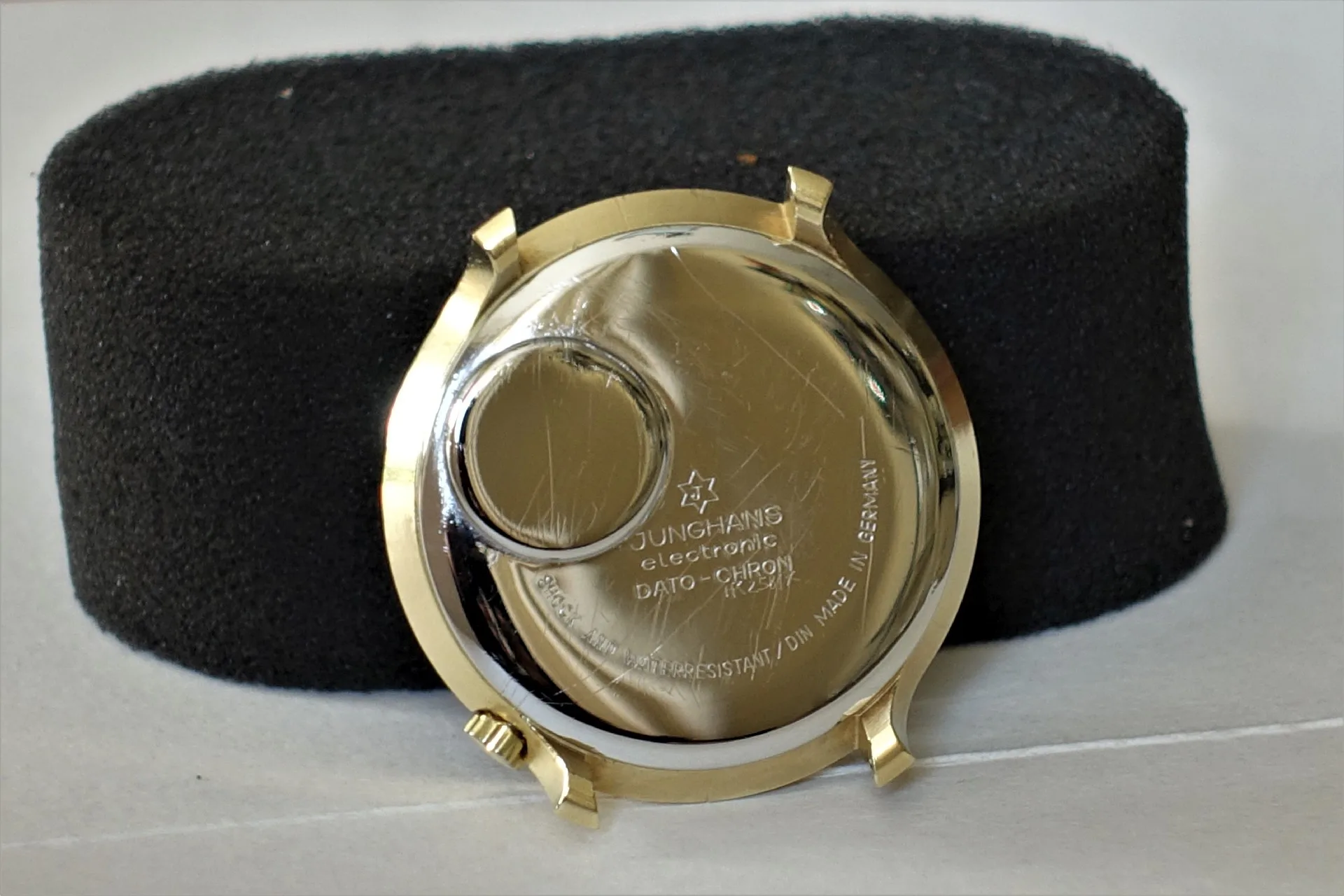 Silberfarbene Gehäuserückseite einer Junghans-Uhr mit Gravur und Batterieabdeckung.