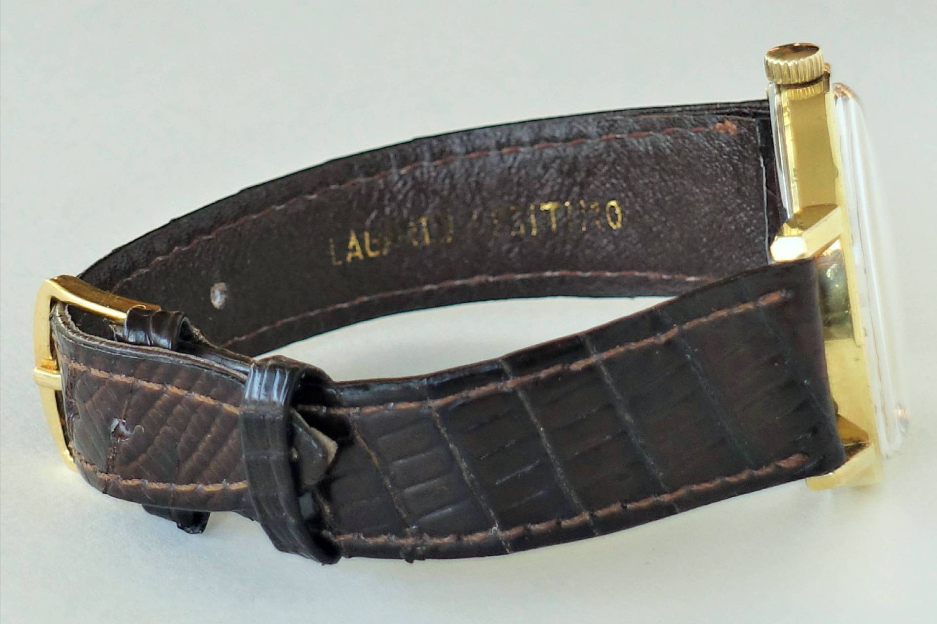 Armbanduhr mit braunem Armband und goldfarbenem Gehäuse.