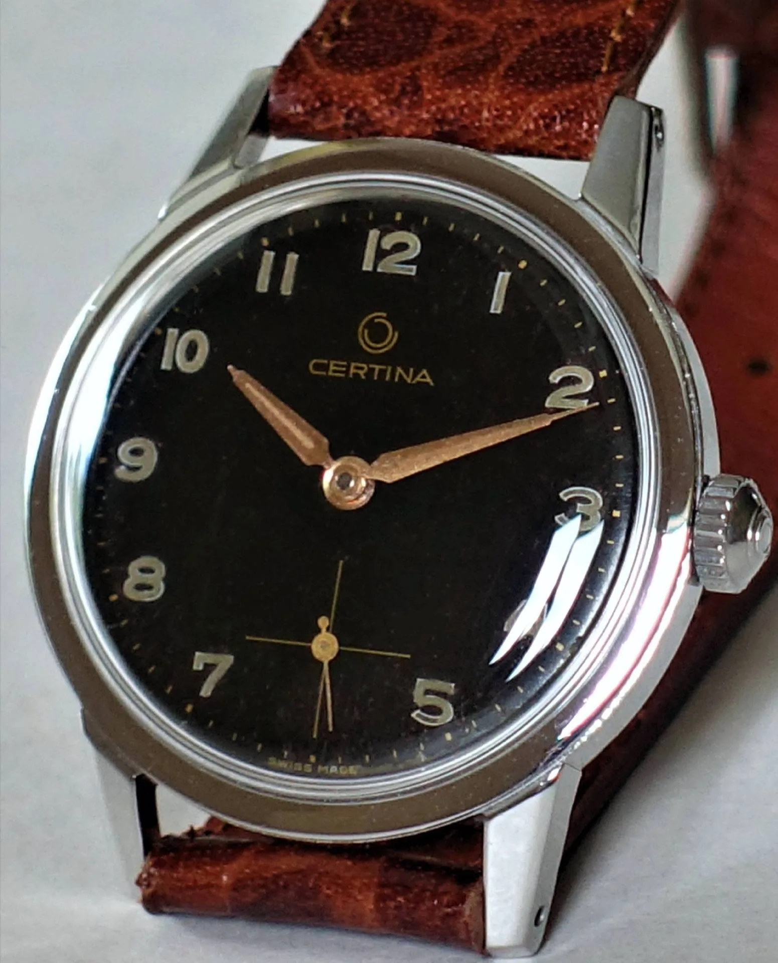 Schwarze Certina Armbanduhr mit silberfarbenem Gehäuse und braunem Armband.