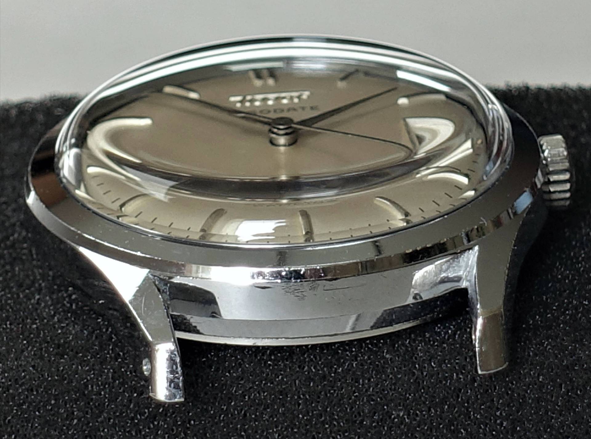 Silberfarbene Armbanduhr mit hellem Zifferblatt und poliertem Gehäuse.