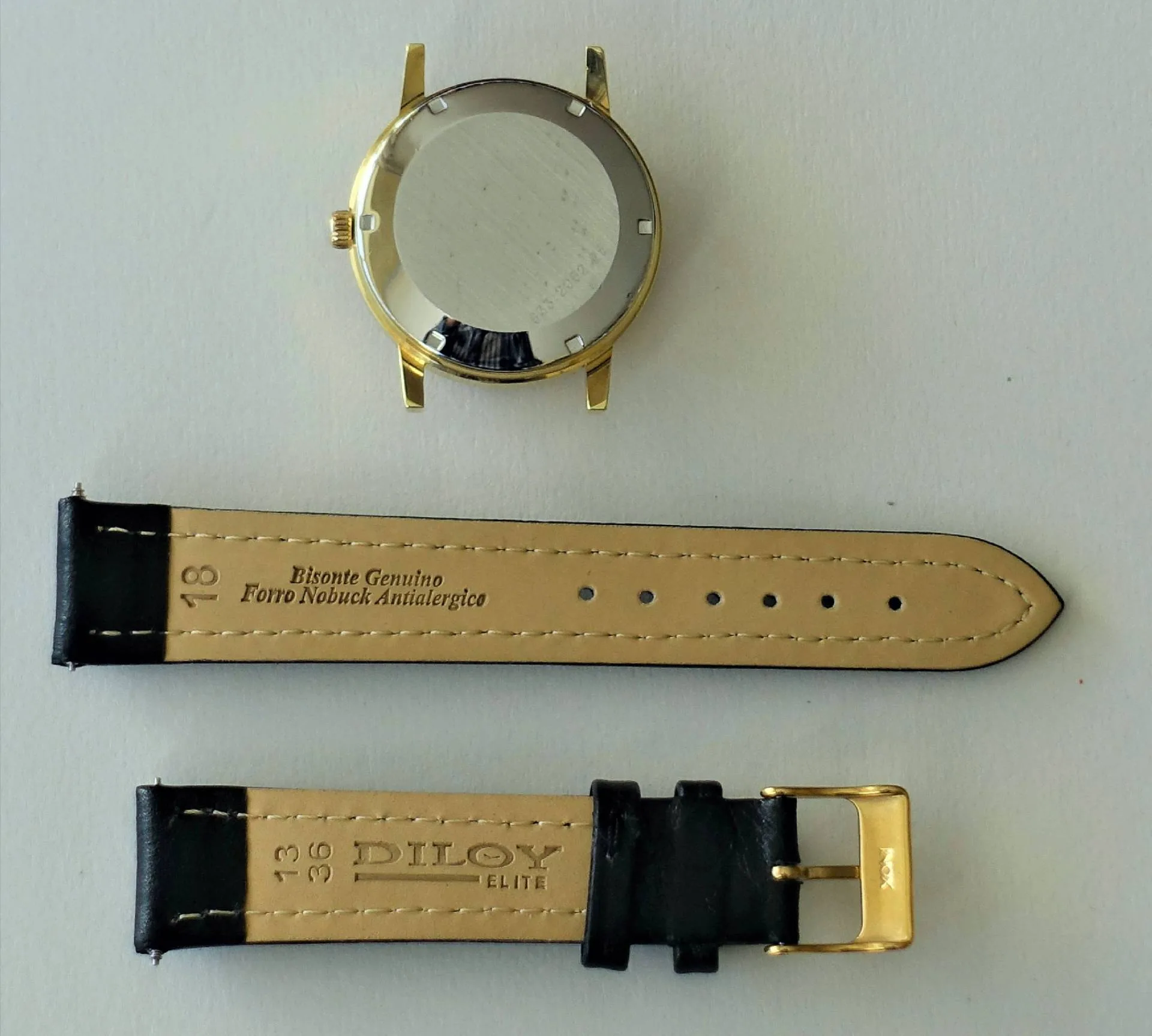 Goldfarbenes Uhrgehäuse mit schwarzem Lederarmband und goldfarbener Schließe.