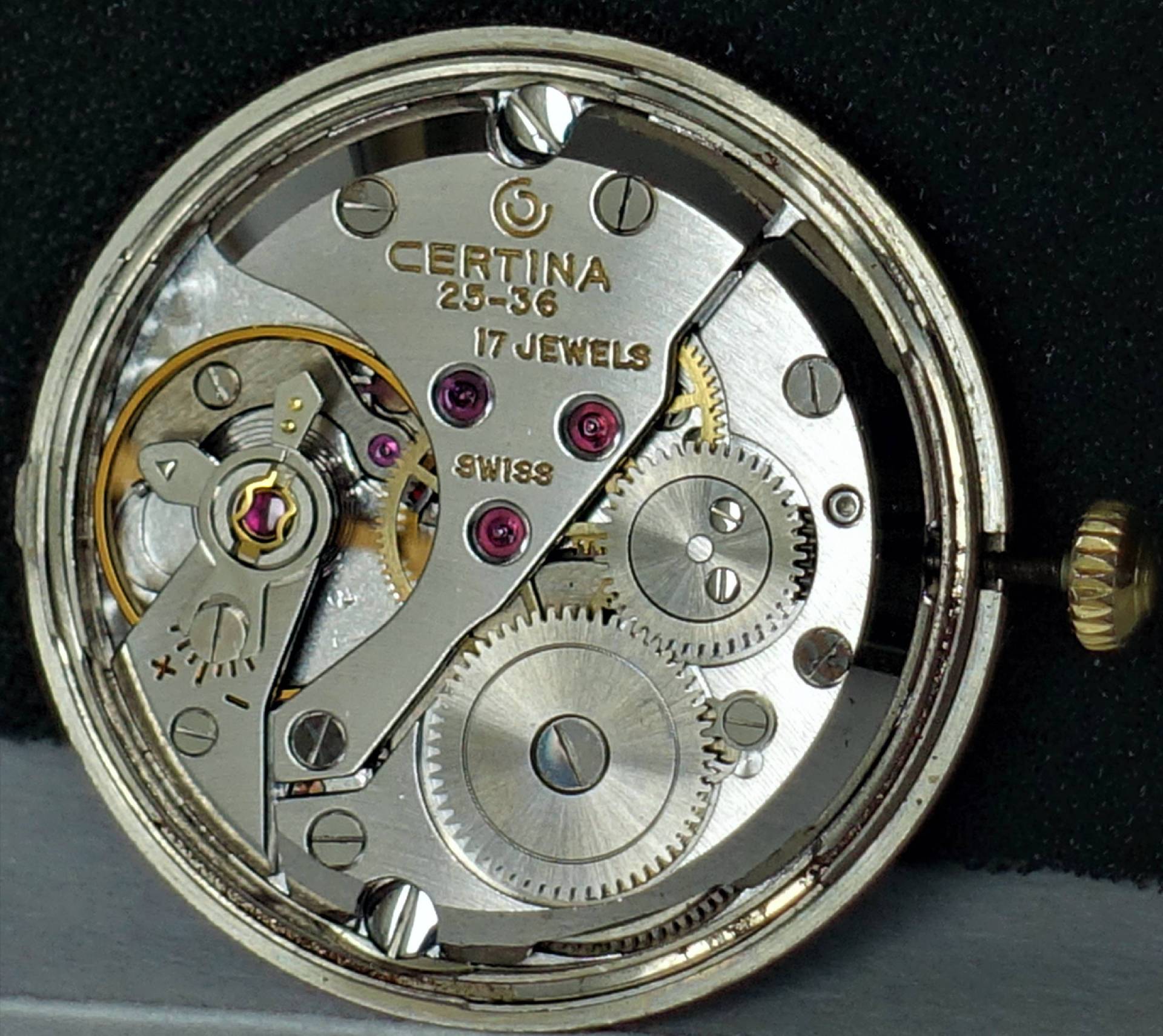 Silberfarbenes mechanisches Uhrwerk Certina 25-36 mit sichtbaren Zahnrädern und roten Lagersteinen.