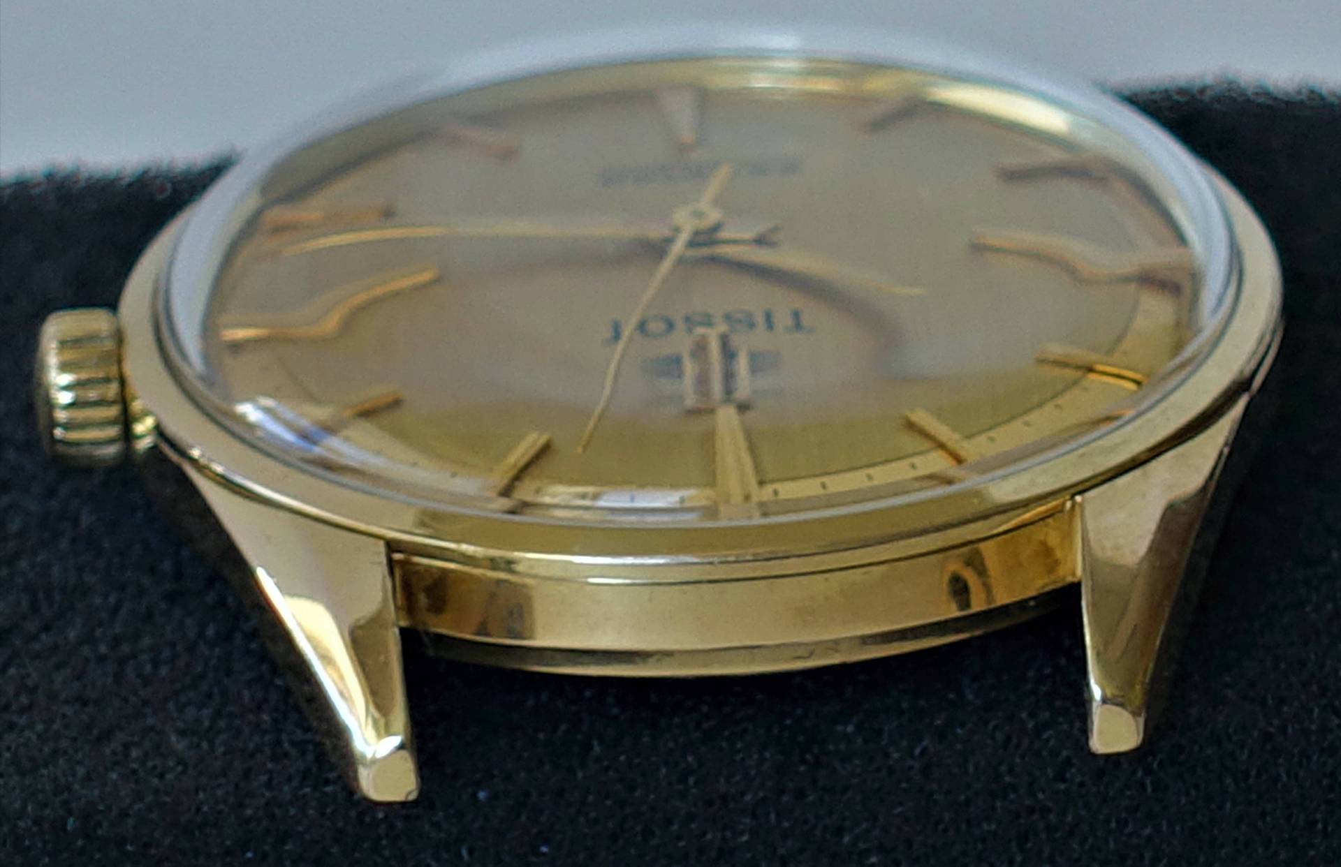 Goldfarbene Armbanduhr mit rundem Gehäuse und goldfarbenen Zeigern.