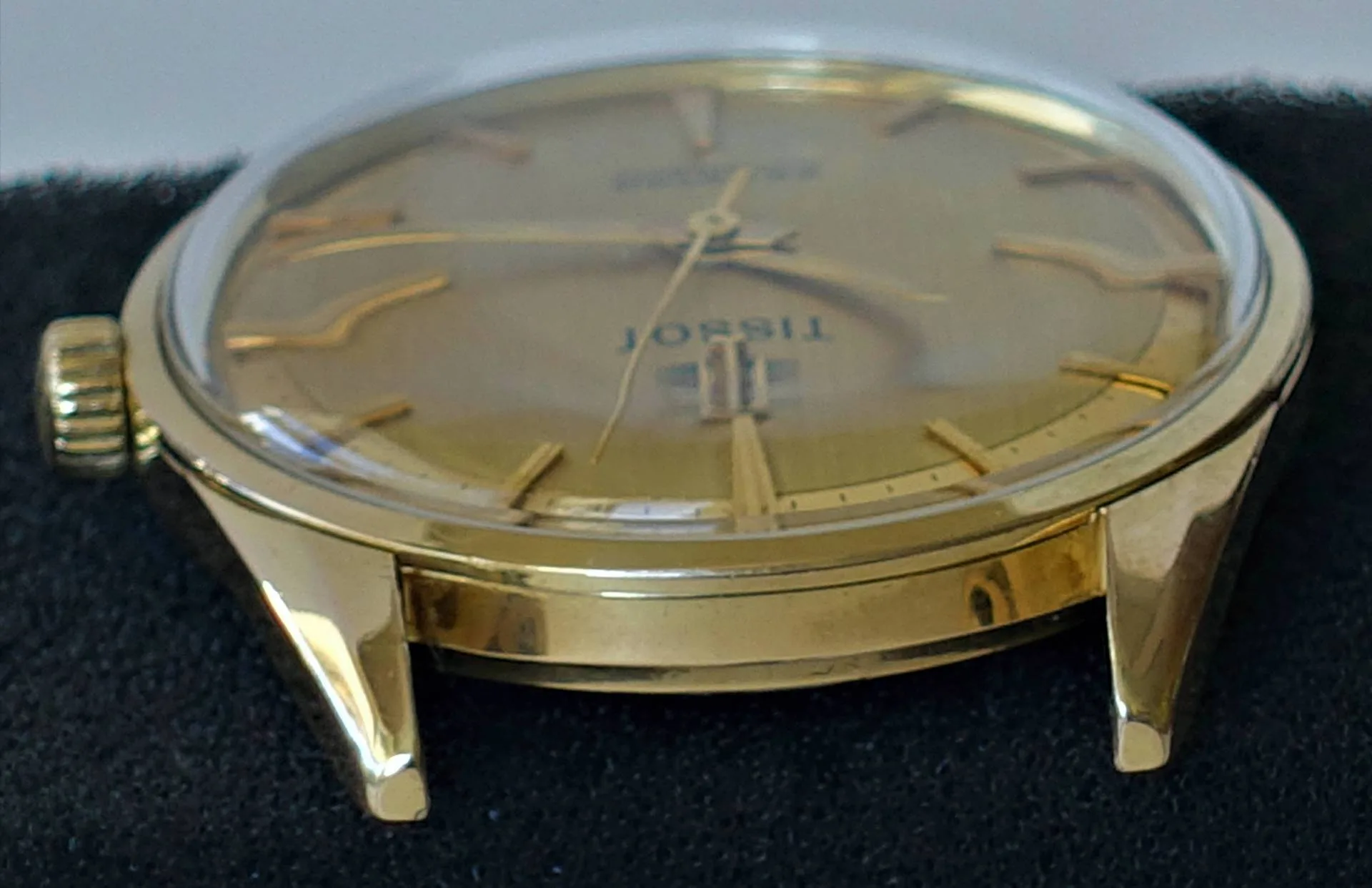 Goldfarbene Armbanduhr mit rundem Gehäuse und goldfarbenen Zeigern.