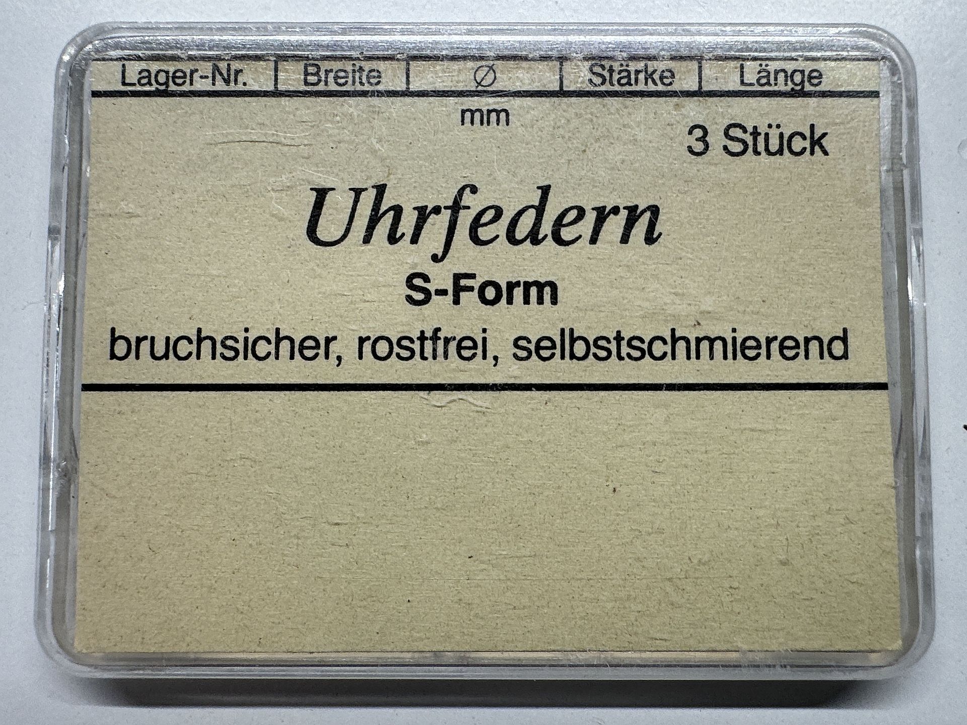 Drei bruchsichere, rostfreie und selbstschmierende Uhrfedern in S-Form in einer transparenten Verpackung.