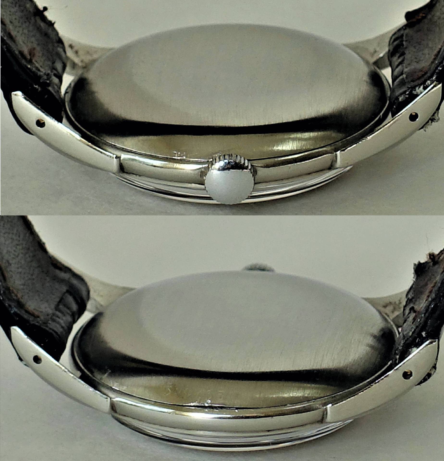 Das Bild zeigt ein silberfarbenes, rundes Uhrgehäuse mit seitlicher Krone und abgenutztem, dunklem Armband aus der Seitenansicht.