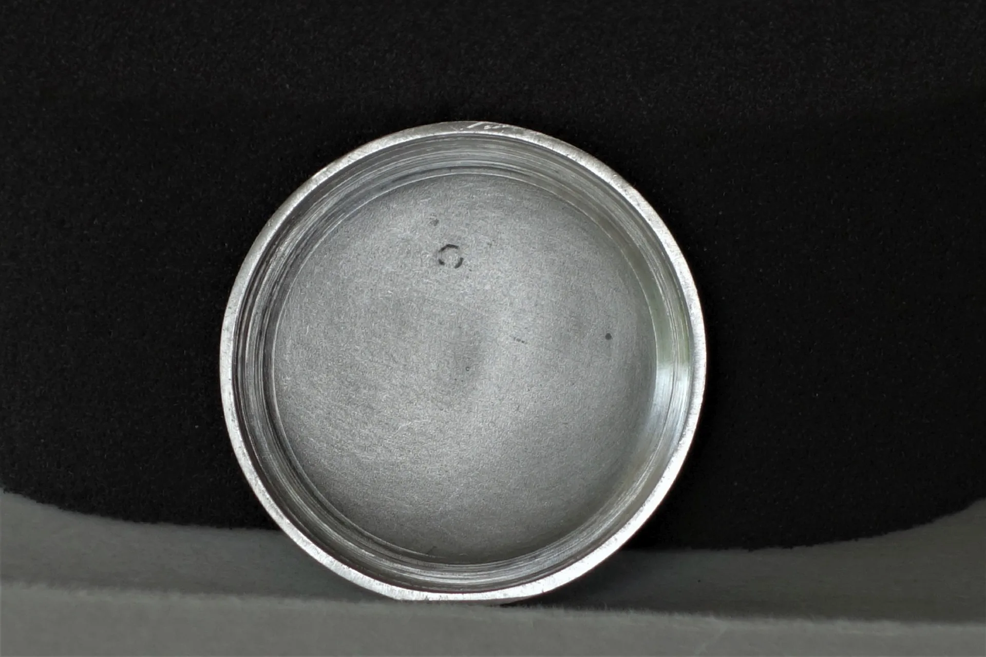 Runder silberfarbener Gehäuseboden für Armbanduhren.