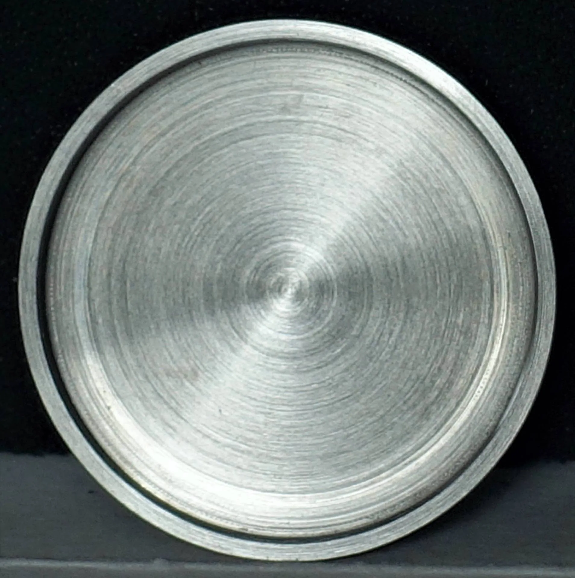 Uhrenboden silberfarben Runder Uhrenboden aus silberfarbenem Metall mit gebürsteter Oberfläche.