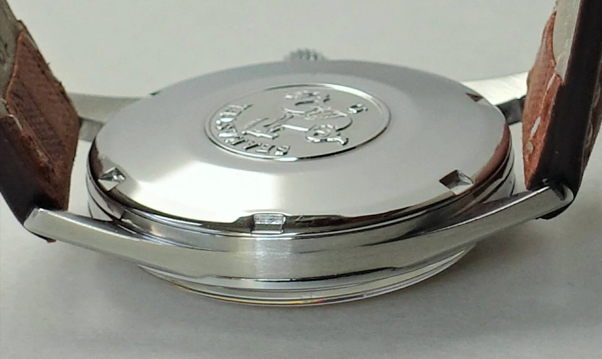 Uhrboden silberfarben Silberfarbener Uhrboden mit Gravur und braunem Lederarmband.