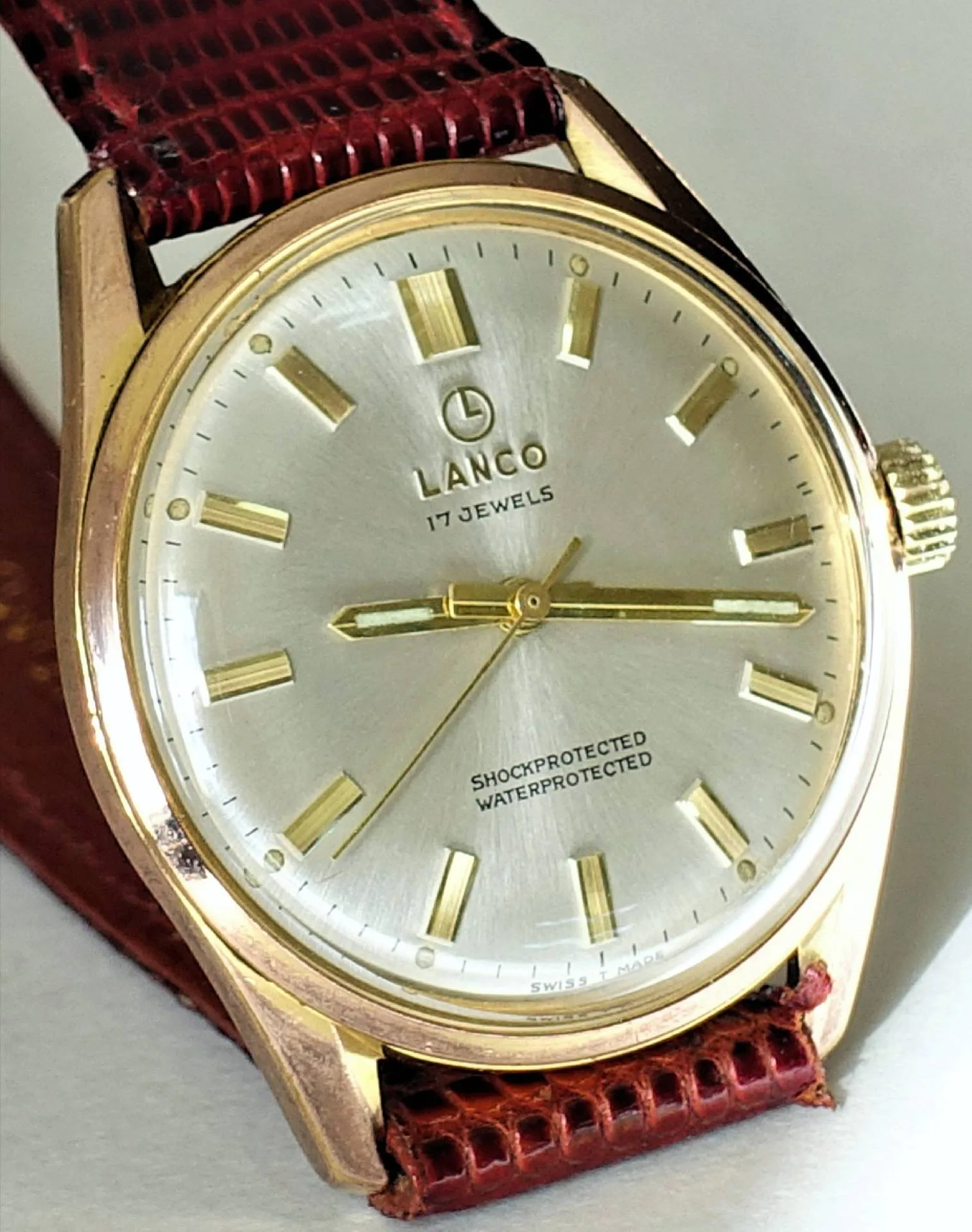 Lanco Armbanduhr goldfarben Goldfarbene Armbanduhr mit silberfarbenem Zifferblatt und braunem Armband.