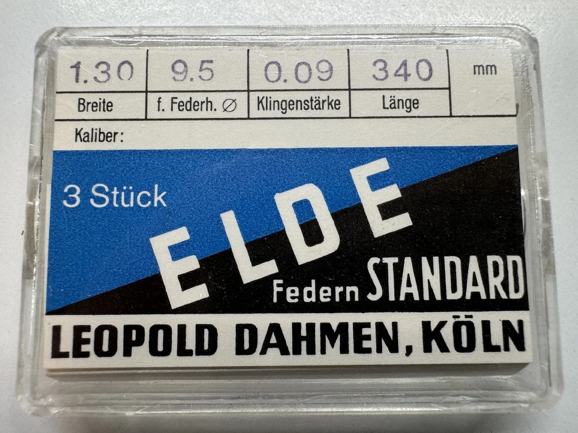 Uhrwerk-Feder Set Verpackung mit drei Ersatz-Federn für Uhrwerke, beschriftet mit technischen Angaben.