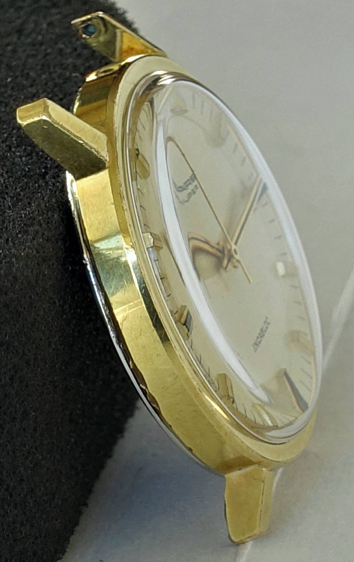 Goldfarbene Dugena Armbanduhr mit hellem Zifferblatt und Zeigern.