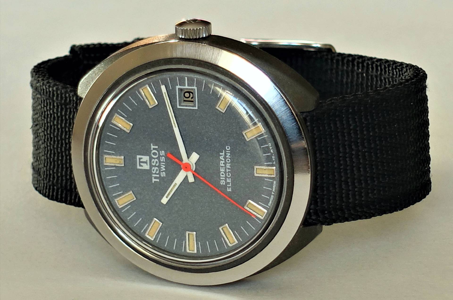 Nahaufnahme einer Vintage Tissot Sideral Electronic Armbanduhr mit rundem Zifferblatt und schwarzem Stoffarmband