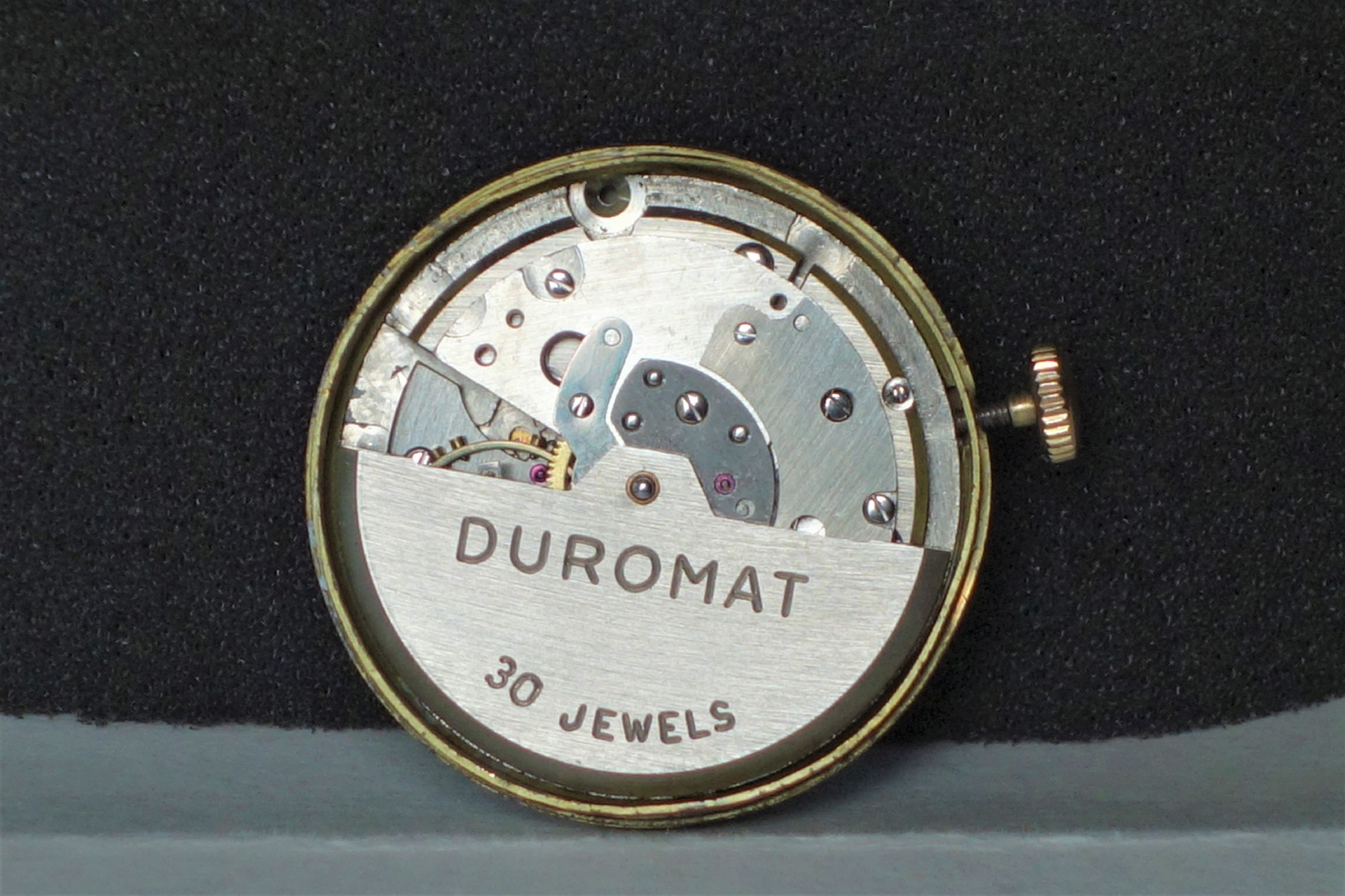 Silberfarbenes mechanisches Uhrwerk mit der Aufschrift "DUROMAT 30 JEWELS".