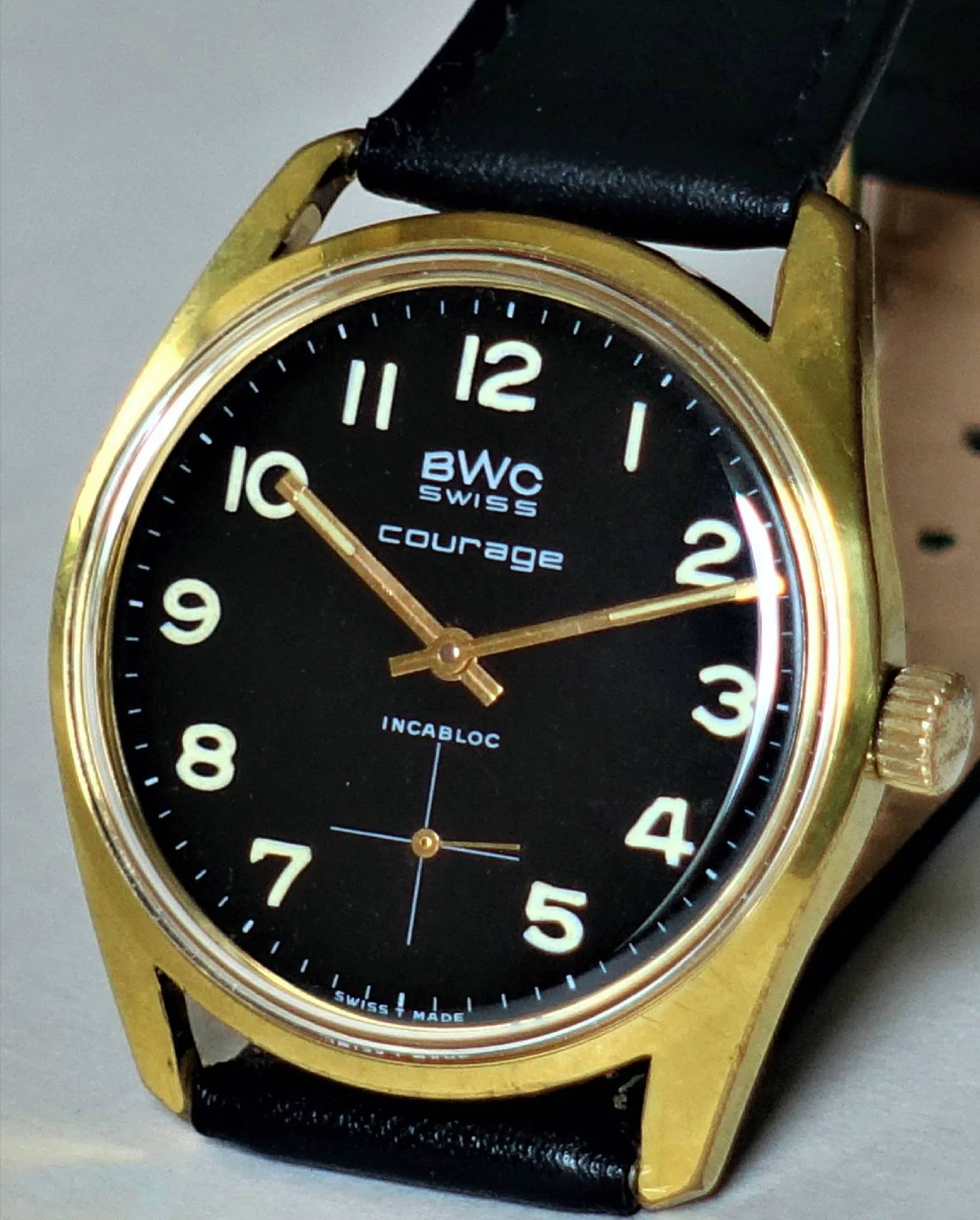 BWC Armbanduhr schwarz gold Schwarze Armbanduhr mit goldfarbenem Gehäuse und schwarzem Lederarmband.