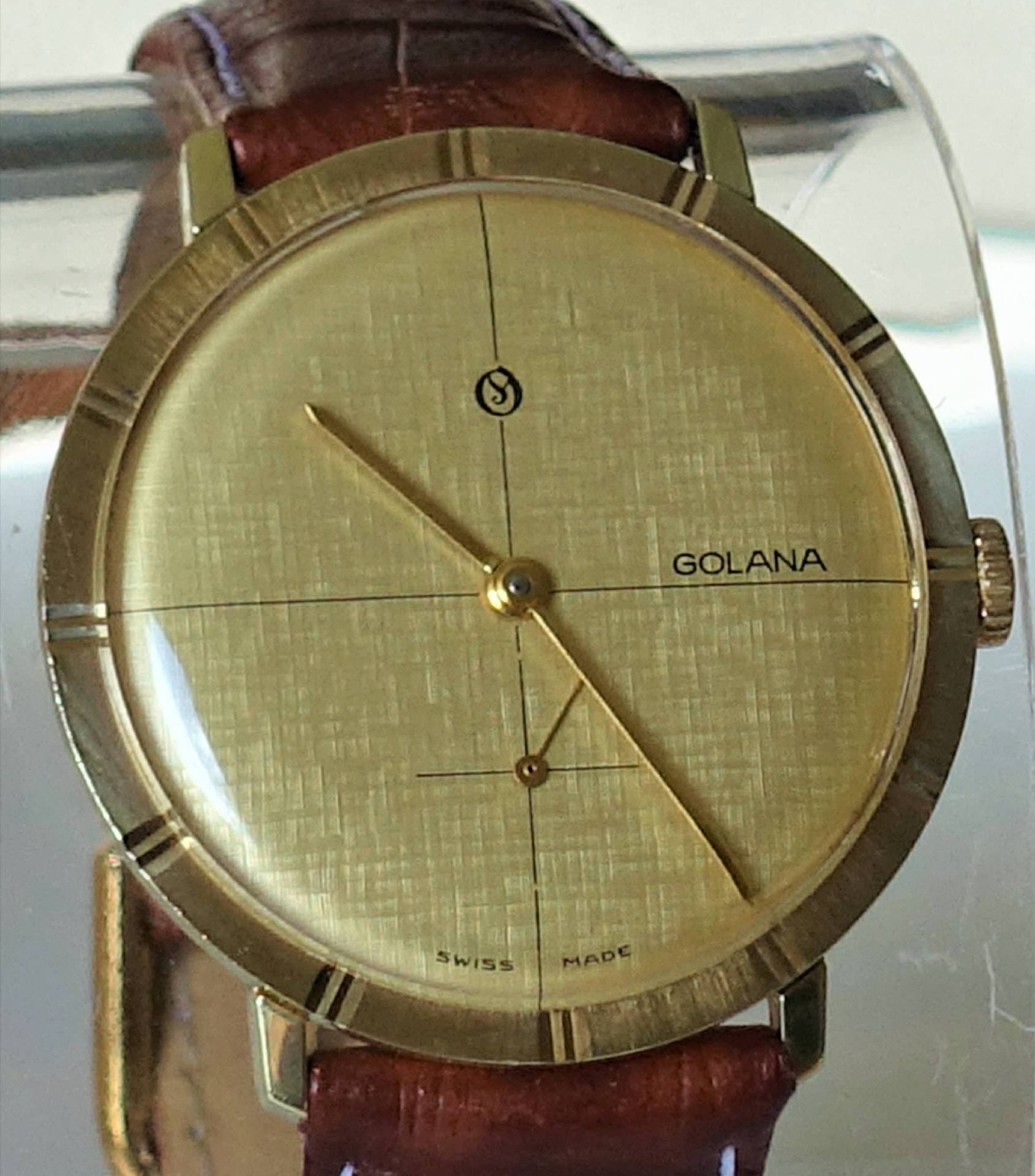 Goldfarbene Armbanduhr mit braunem Armband und schlichtem Zifferblatt.