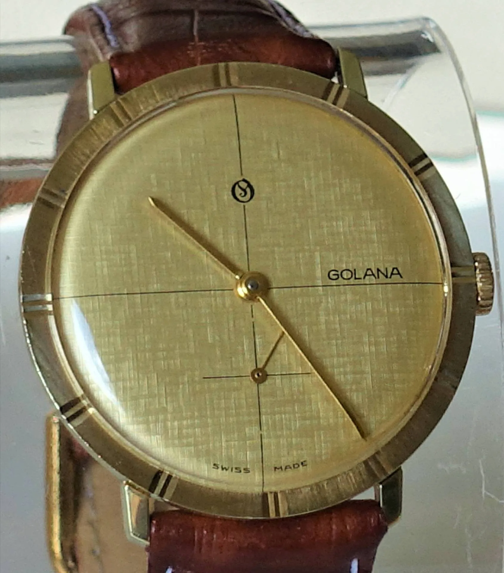 Golduhr mit braunem Armband Goldfarbene Armbanduhr mit braunem Armband und schlichtem Zifferblatt.