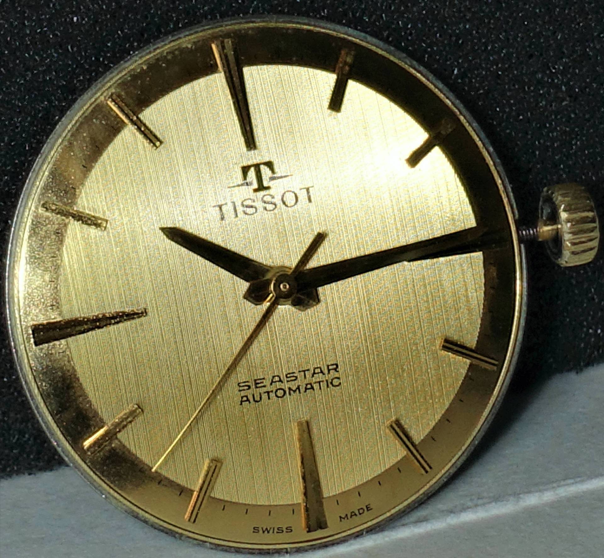Goldenes Tissot Seastar Automatik-Uhrwerk mit goldfarbenem Zifferblatt und Zeigern.