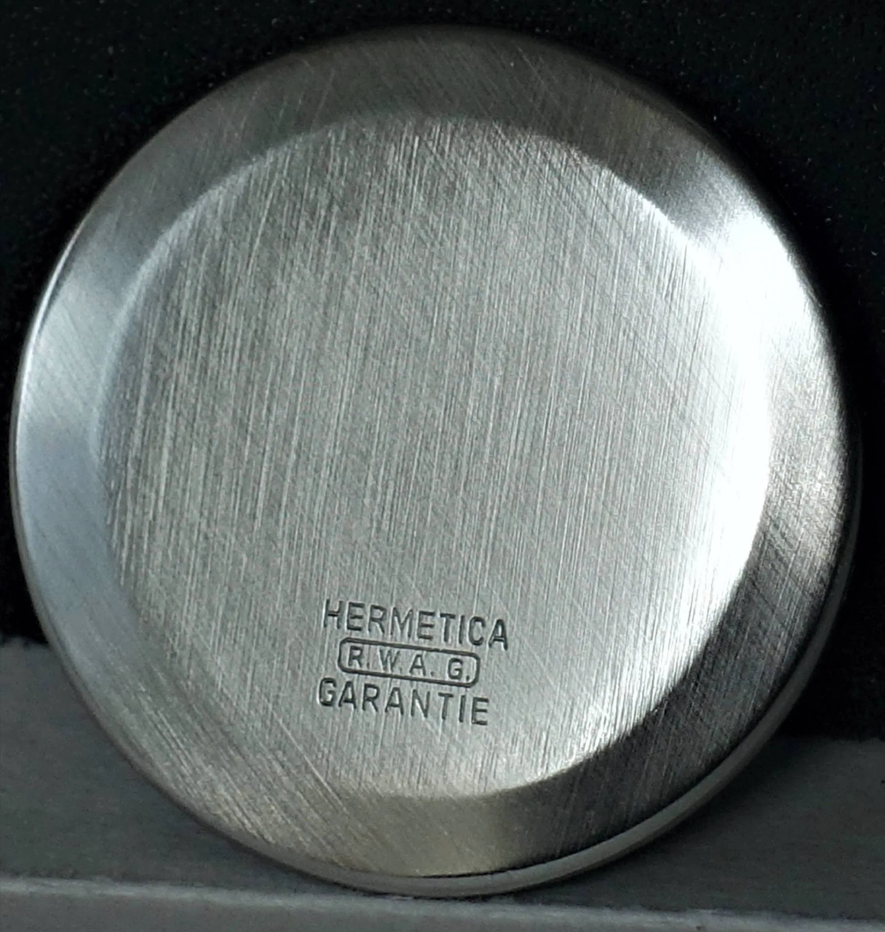 Uhrboden silberfarben Runder silberfarbener Uhrboden mit Gravur "Hermetica R.W.A.G Garantie".