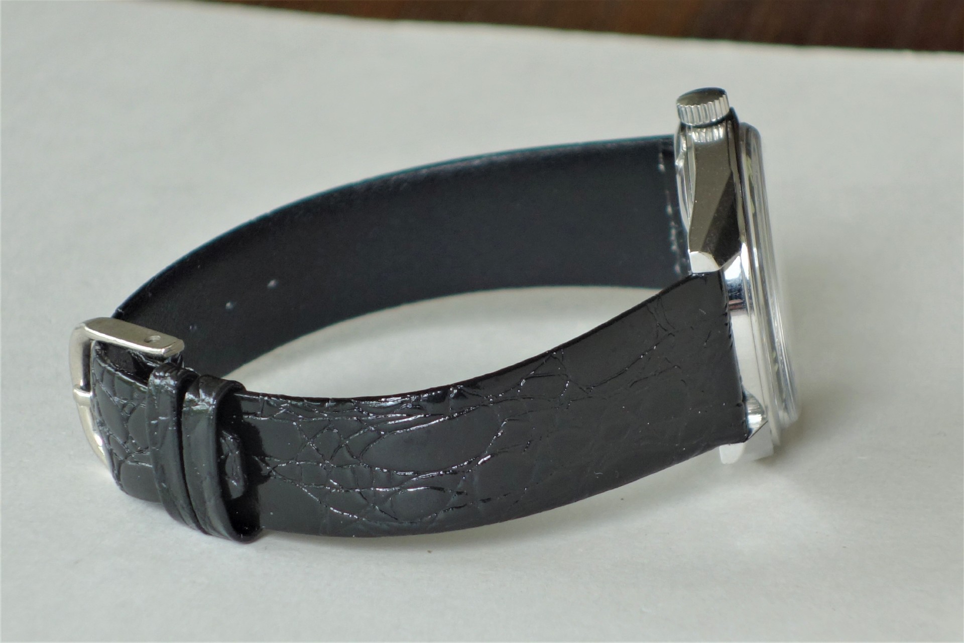 Armbanduhr mit schwarzem Armband und silberfarbenem Gehäuse.