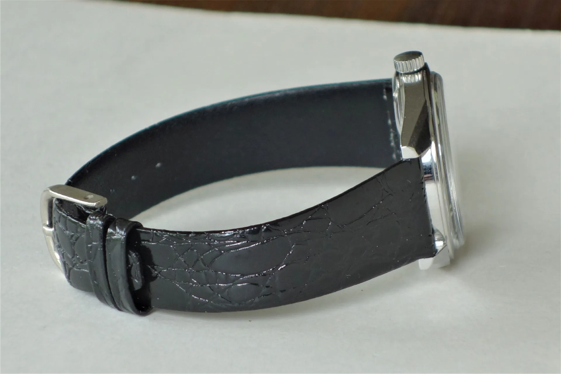 Armbanduhr mit schwarzem Armband und silberfarbenem Gehäuse.