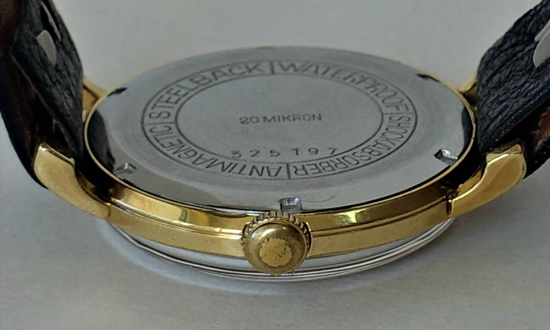 Uhrboden silberfarben Silberfarbener runder Uhrenboden mit Gravur und goldfarbener Krone.