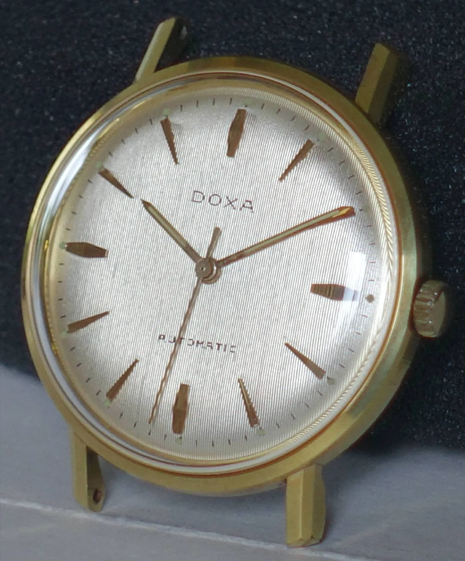 Goldfarbene Doxa Armbanduhr mit hellem Zifferblatt und goldfarbenen Indizes.
