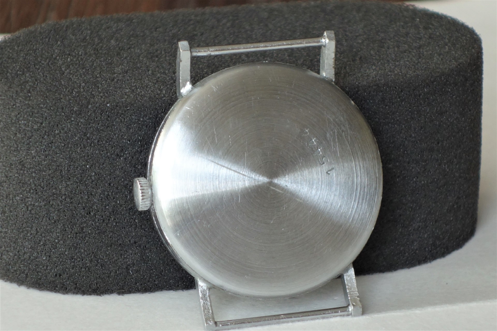 Rundes silberfarbenes Uhrengehäuse mit Krone und Bandanstößen.