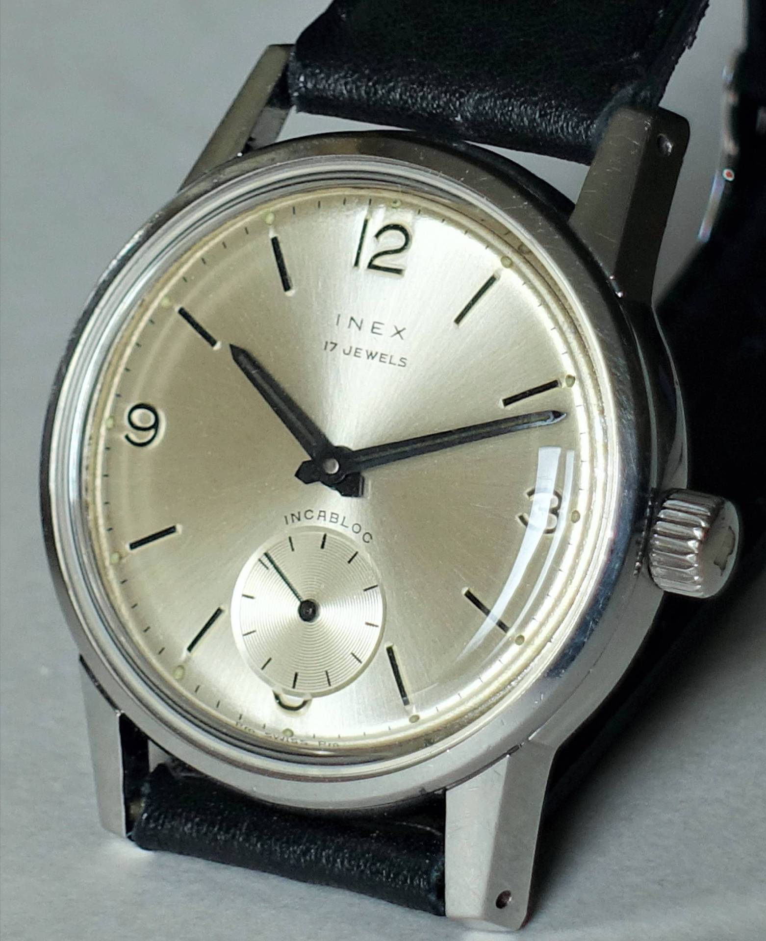 Schöne INEX Uhr mit Silberzifferblatt und schwarzem Lederarmband