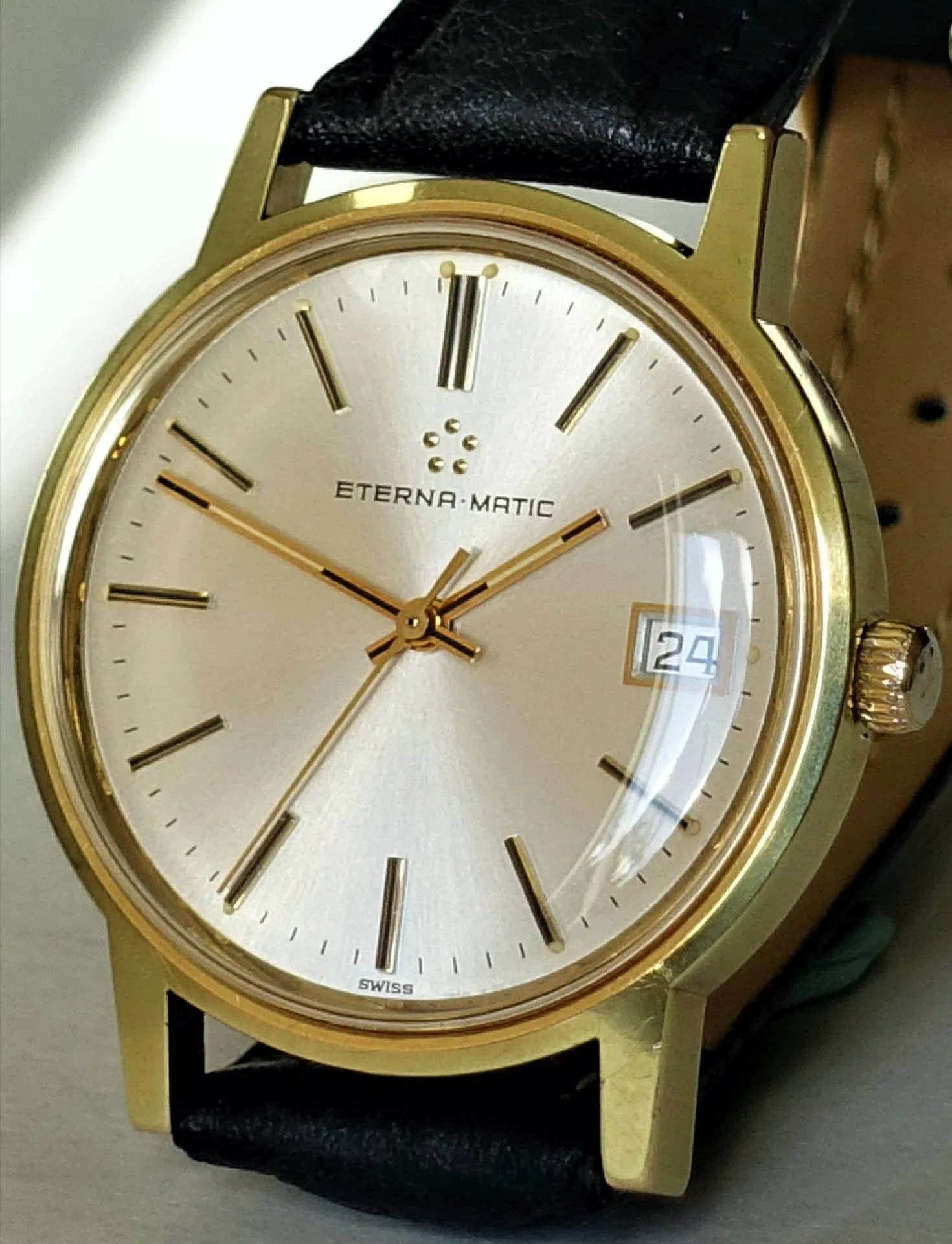 Armbanduhr goldfarben Goldfarbene Armbanduhr mit hellem Zifferblatt, schwarzen Indizes und schwarzem Armband.