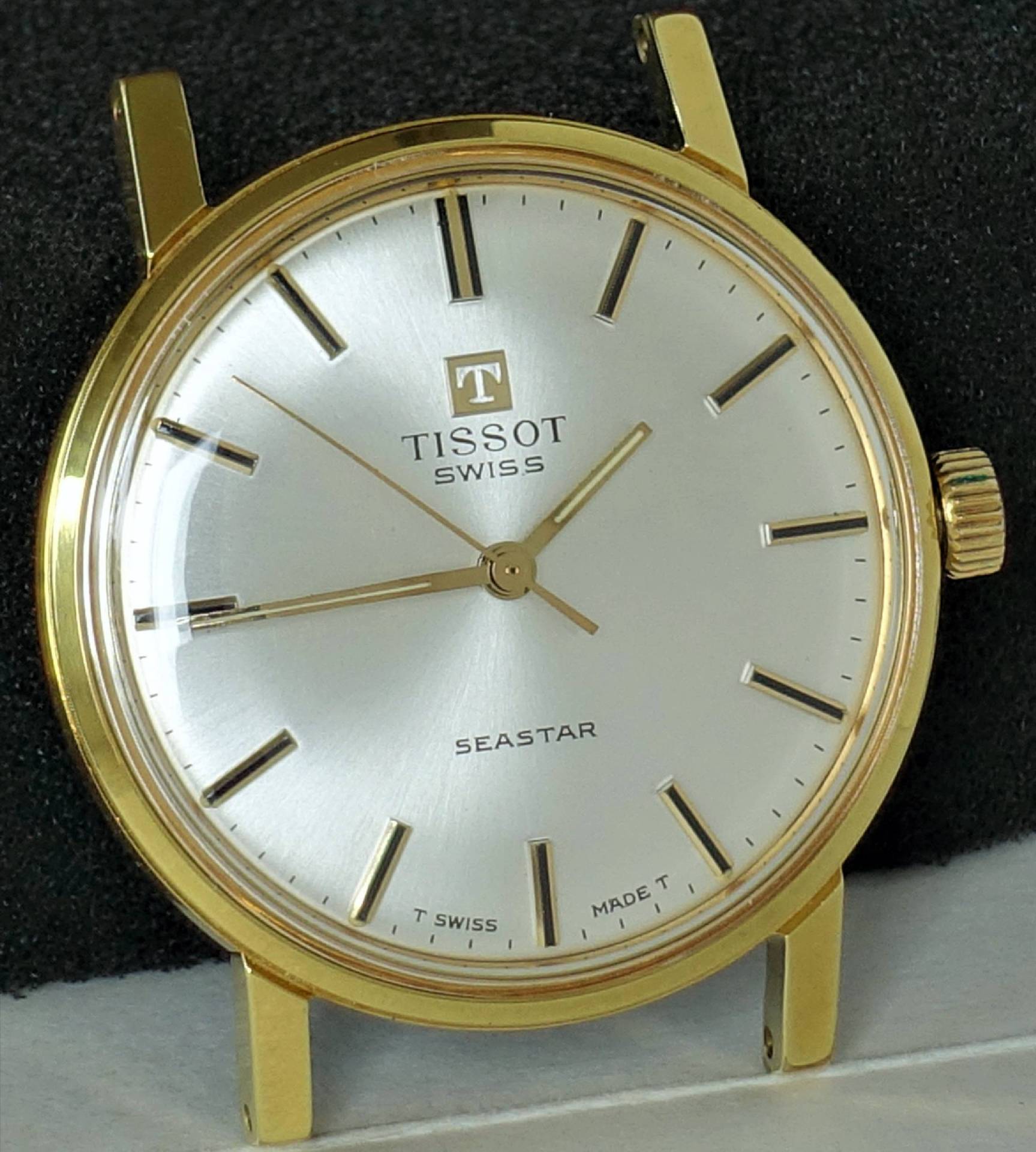 Goldfarbene Armbanduhr mit silberfarbenem Zifferblatt und schlichten Indizes.