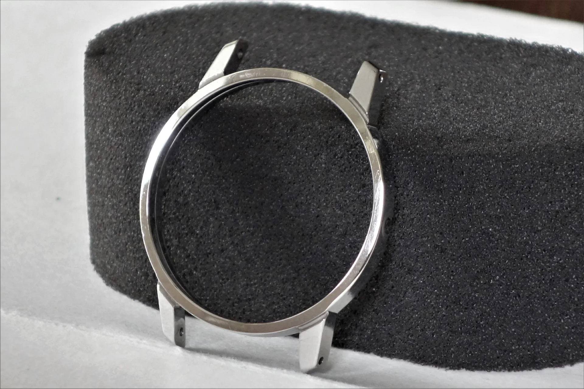 Rundes silberfarbenes Uhrengehäuse ohne Uhrwerk und Armband.