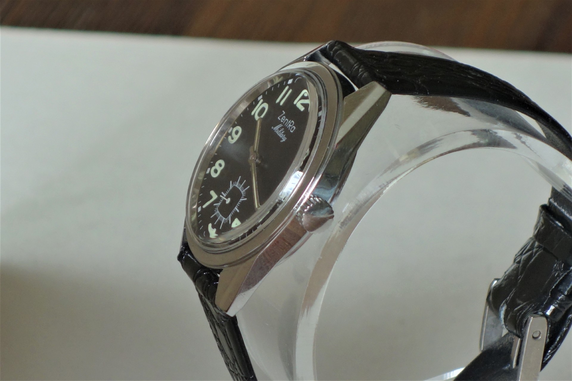 Analoge Armbanduhr mit schwarzem Zifferblatt und schwarzem Armband.