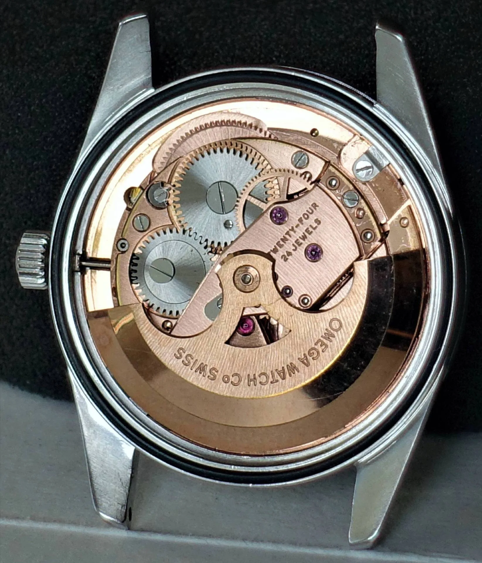 Mechanisches Automatik-Uhrwerk von Omega in silberner und goldfarbener Ausführung, sichtbar im offenen Uhrengehäuse.