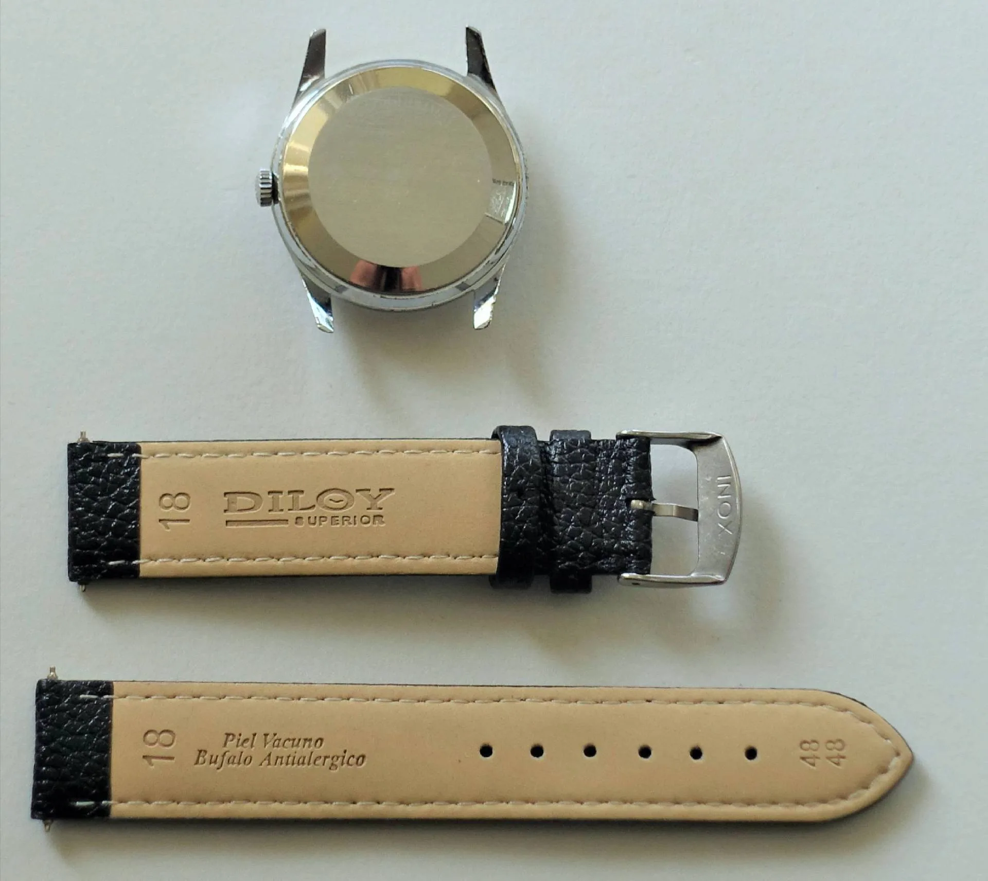 Uhrengehäuse silberfarben und Lederarmband schwarz Silberfarbenes Uhrengehäuse mit schwarzem Lederarmband und Metallschließe.
